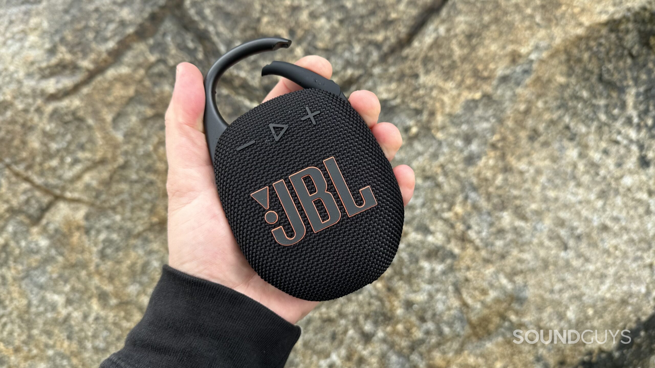 JBL Clip 5 open A JBL Clip 5 in hand holding the carabiner clip open.
