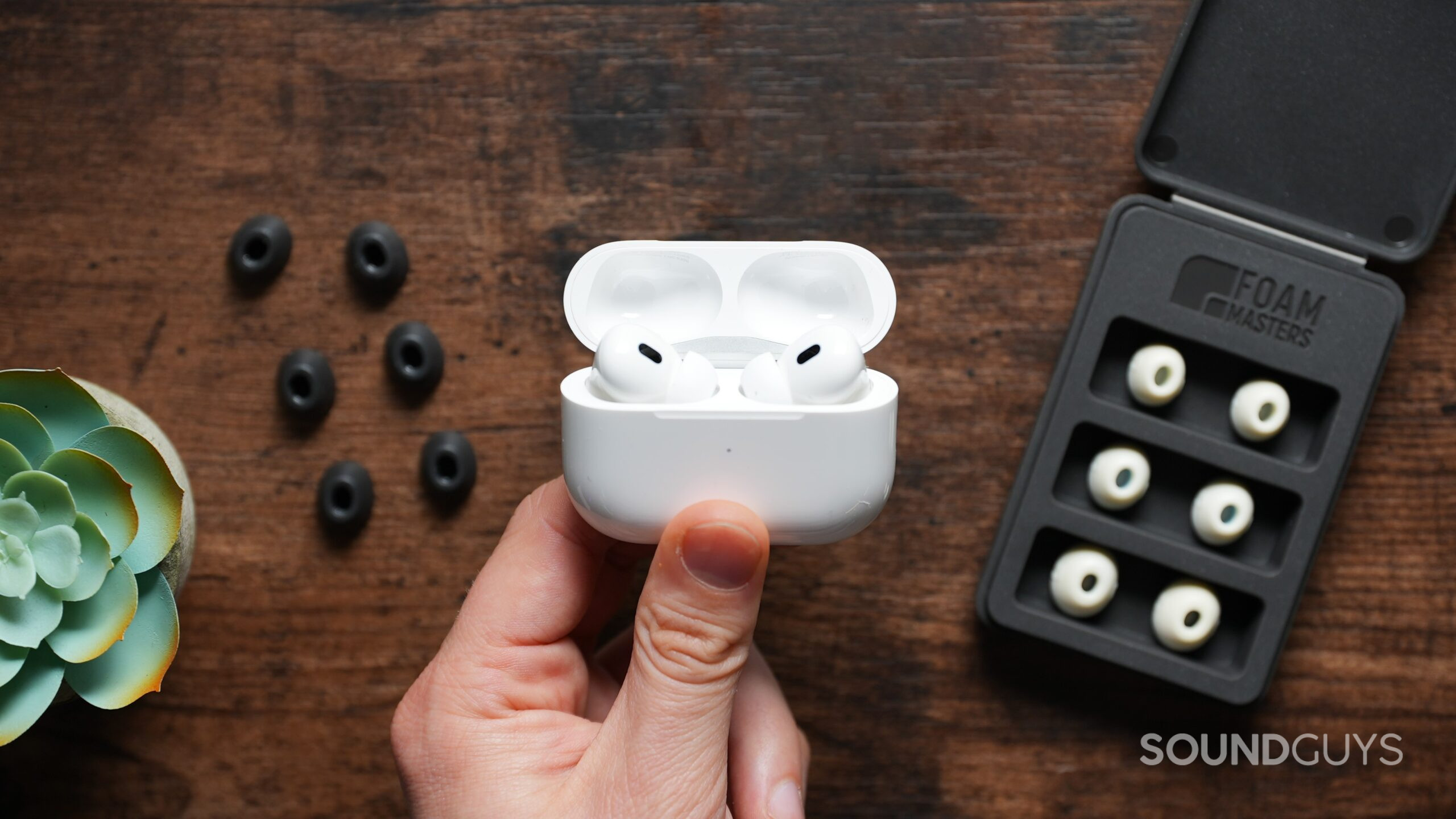 A hand holding the airpods pro 2 with eartips A hand holding the airpods pro 2 with eartips