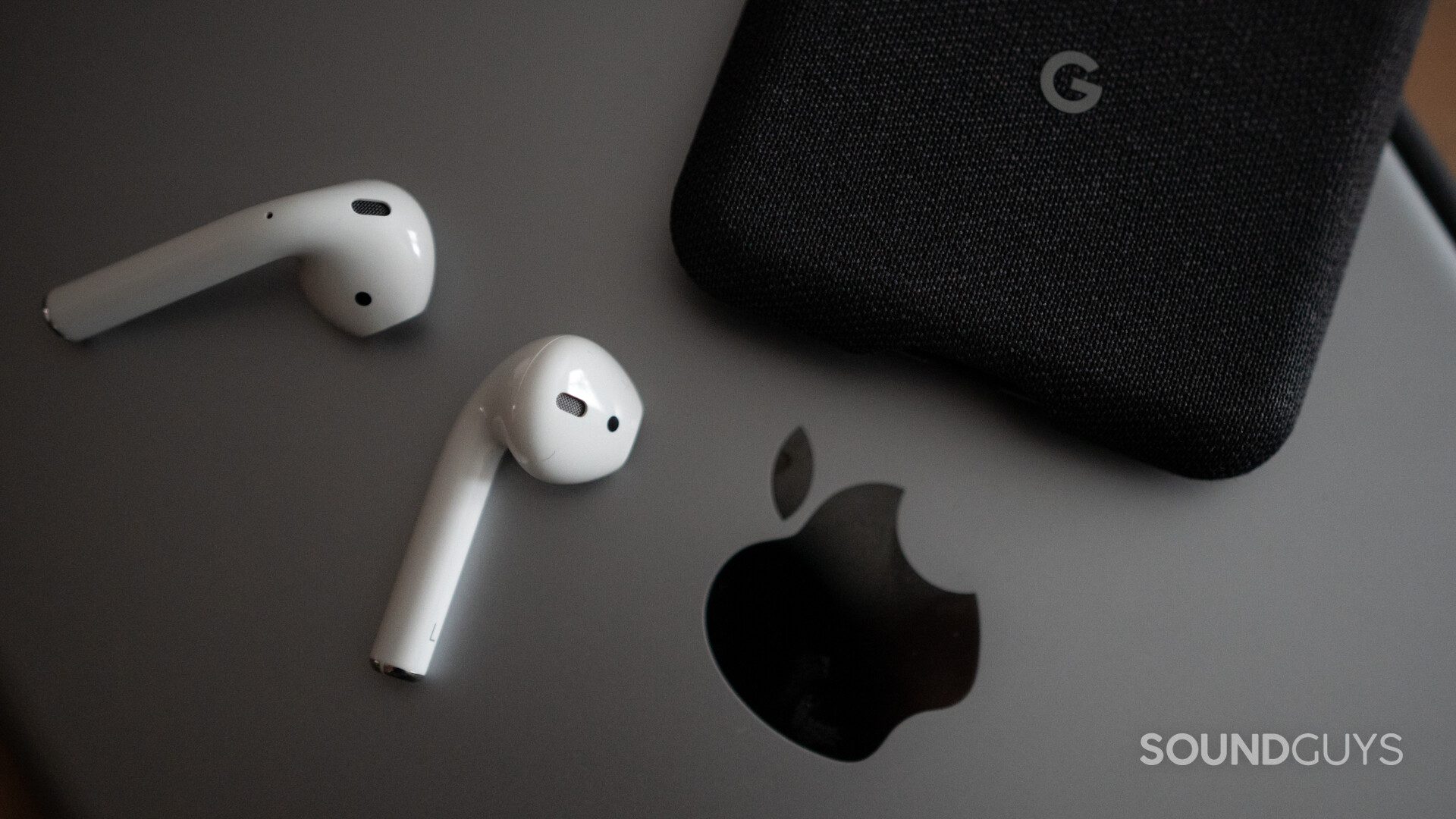 Airpods 2-4 The Airpods on top of an iPad and next to the Google Pixel 3.