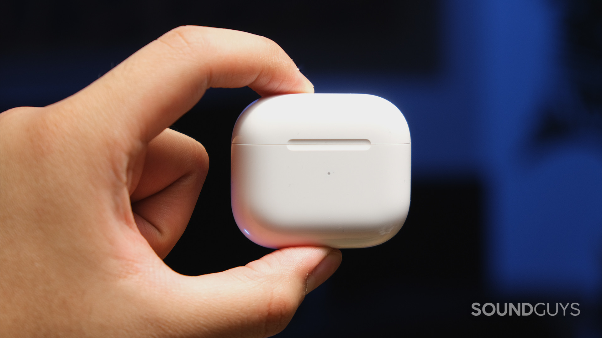 Apple AirPods 3rd Generation_10 A hand pinches the Apple AirPods (3rd generation) charging case to display its plain white exterior and minimalist indentation.