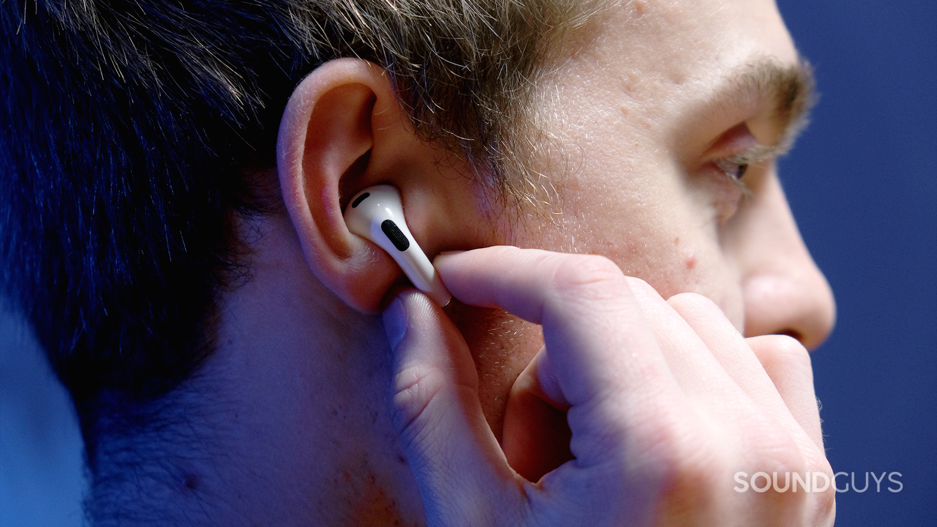 Apple AirPods 3rd Generation_2 A hand holds the AirPods (3rd generation) in the right ear while touching the force sensor stem.