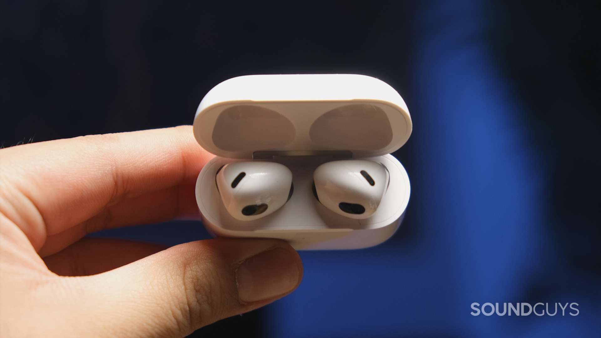 Apple AirPods 3rd Generation_7 A hand holds the Apple AirPods (3rd generation) case at an angle to display shape of the earbuds.