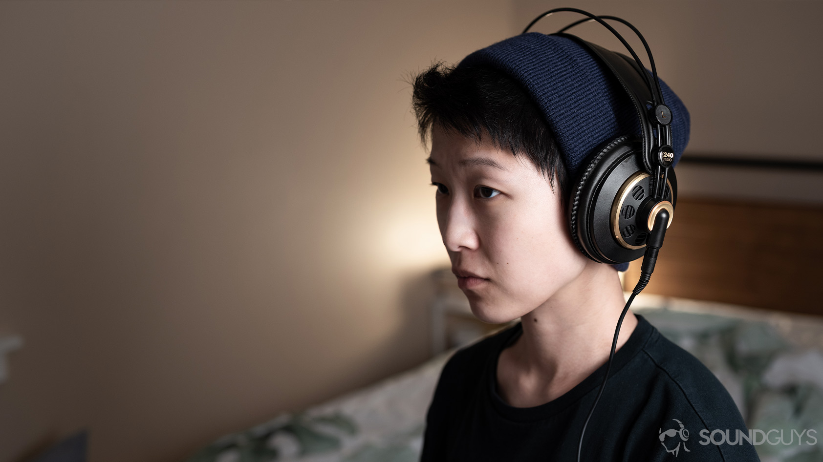 AKG K240-open headphones woman wearing A photo of the AKG K240 Studio semi-open headphones being worn by a woman angled slightly away from the camera.