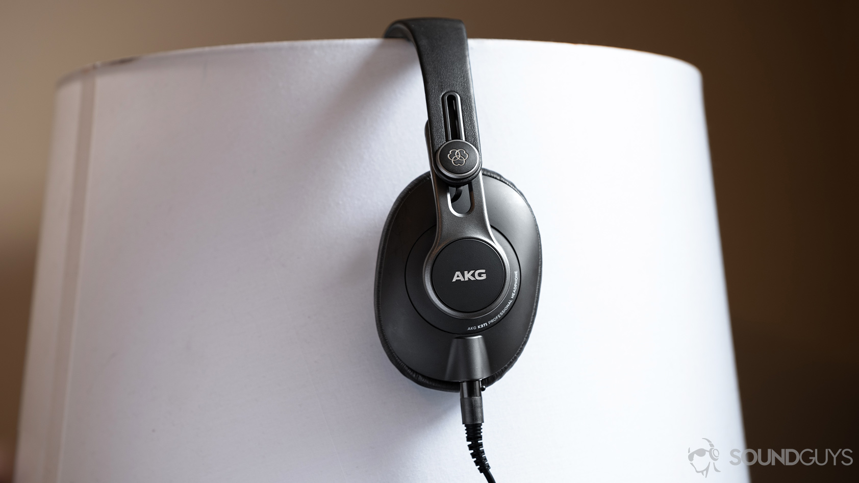 AKG K371-over ear wired headphones profile A picture of the AKG K371 wired over-ear headphones in profile on a lampshade.