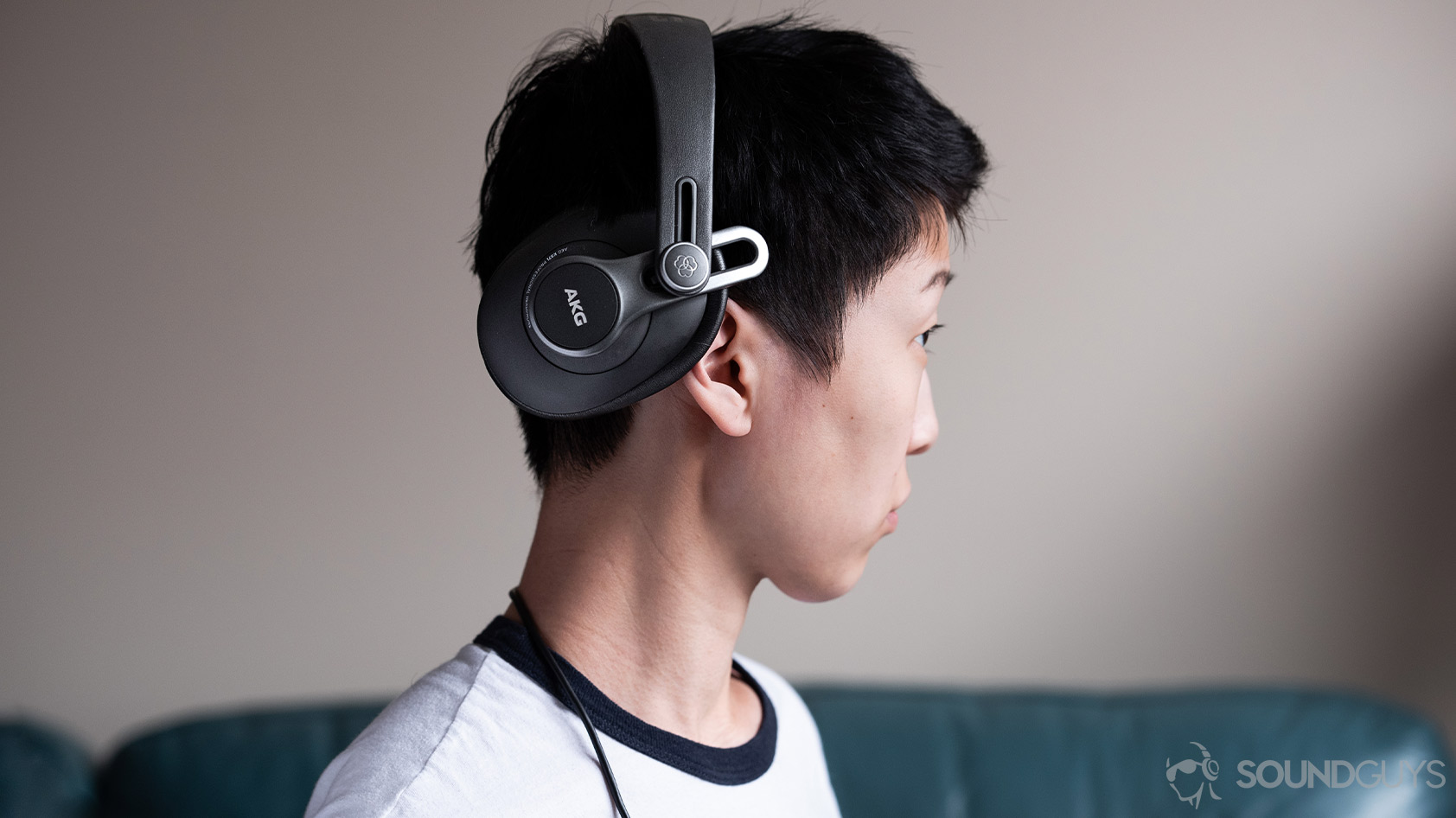 AKG K371-over ear wired headphones worn ear cup The AKG K371 wired over-ear headphones' ear cup rotated back 45 degrees while being worn by a woman in profile.