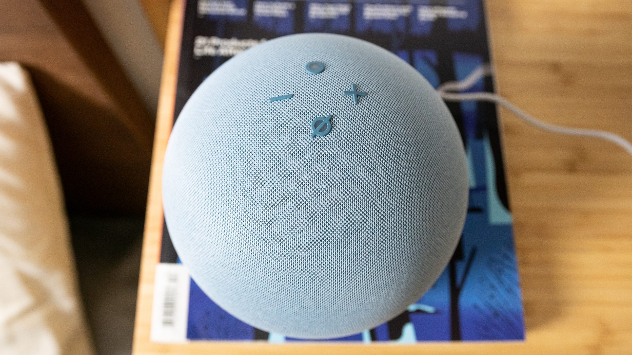 Amazon Echo 4th gen playback controls Amazon Echo 4th gen on top of a magazine.