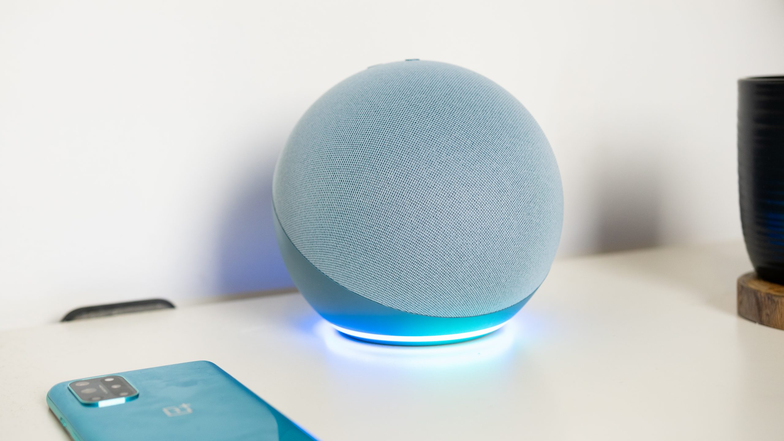 Amazon Echo 4th gen Alexa LED light The Twilight blue Amazon Echo 4th gen with the LED light glowing blue on a white desk.