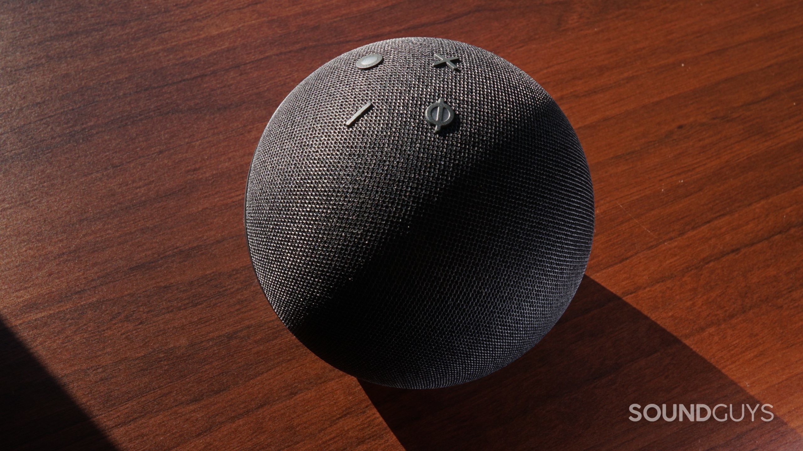 Amazon-Echo-Dot-(5th-Gen)-controls-shot The Amazon Echo Dot (5th Gen) sits on a wooden surface in sunlight with the controls facing up.