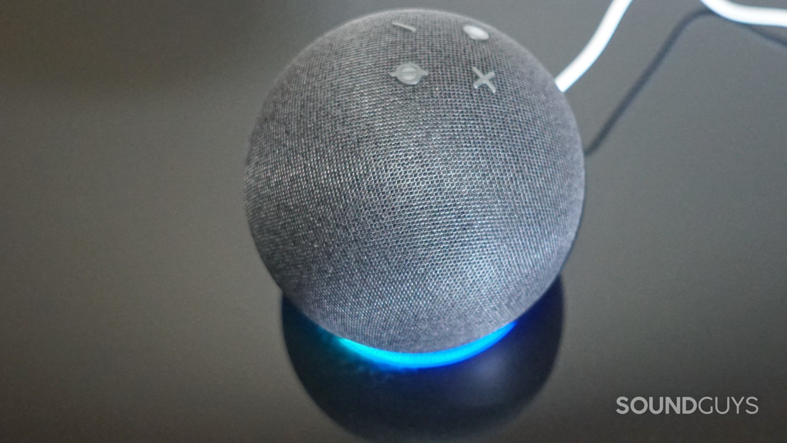 amazon-echo-dot-5th-gen-LED The Amazon Echo Dot (5th Gen) sits on a reflective black surface with its LED light turned.