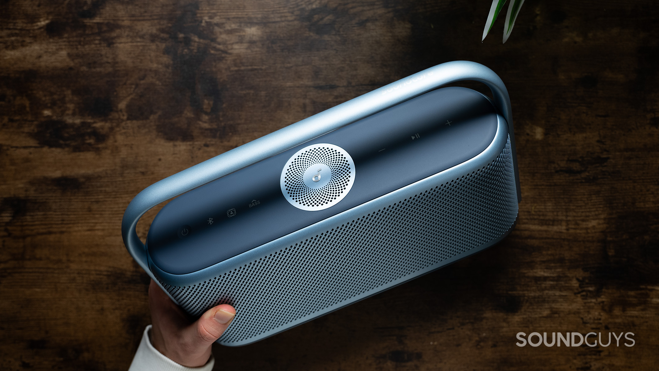 Anker Soundcore Motion X600 handle Anker Soundcore Motion X600 speaker held in hand above a table.