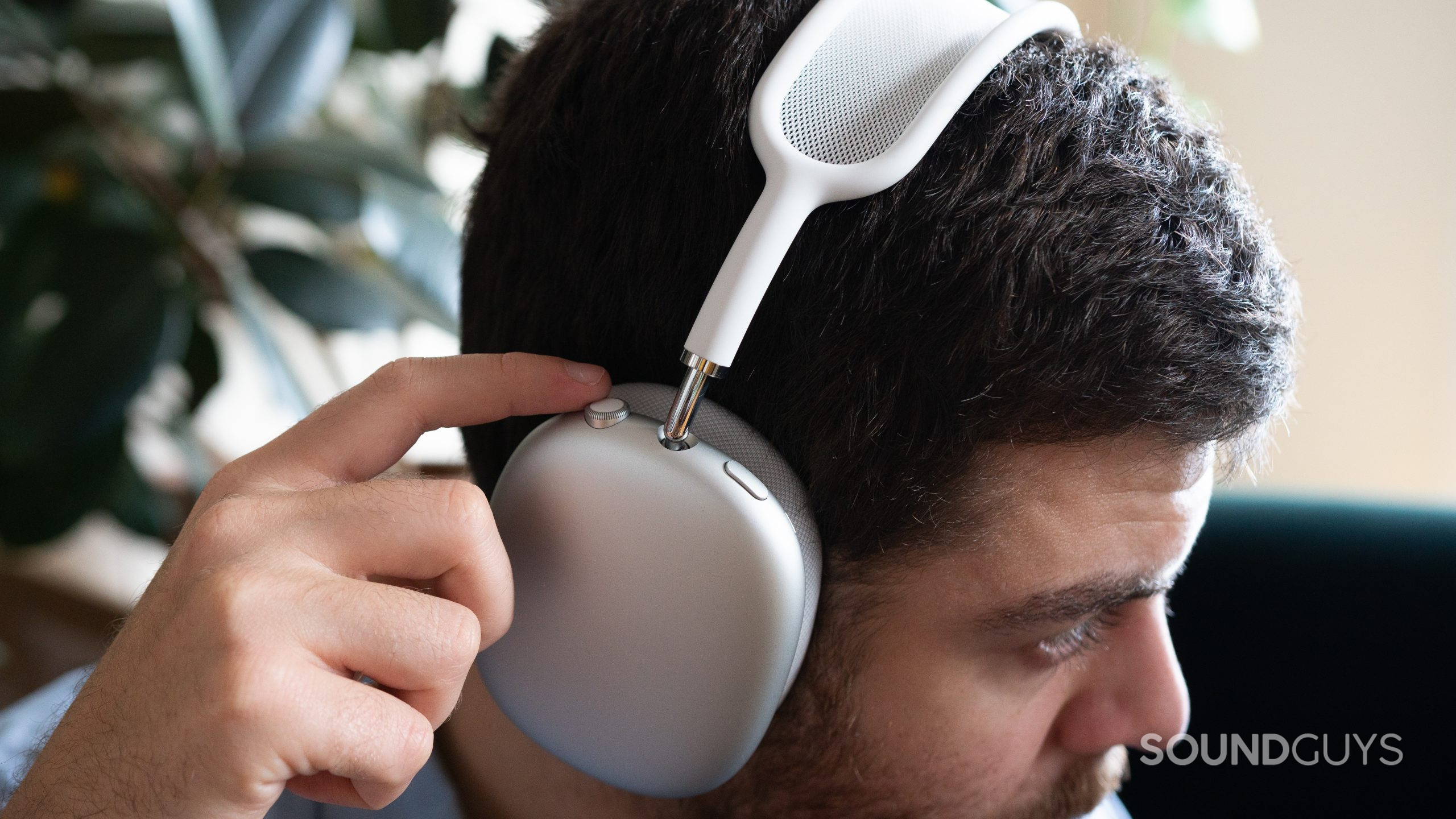 Apple AirPods Max volume control. A man wears the Apple AirPods Max and adjusting volume via the digital crown.