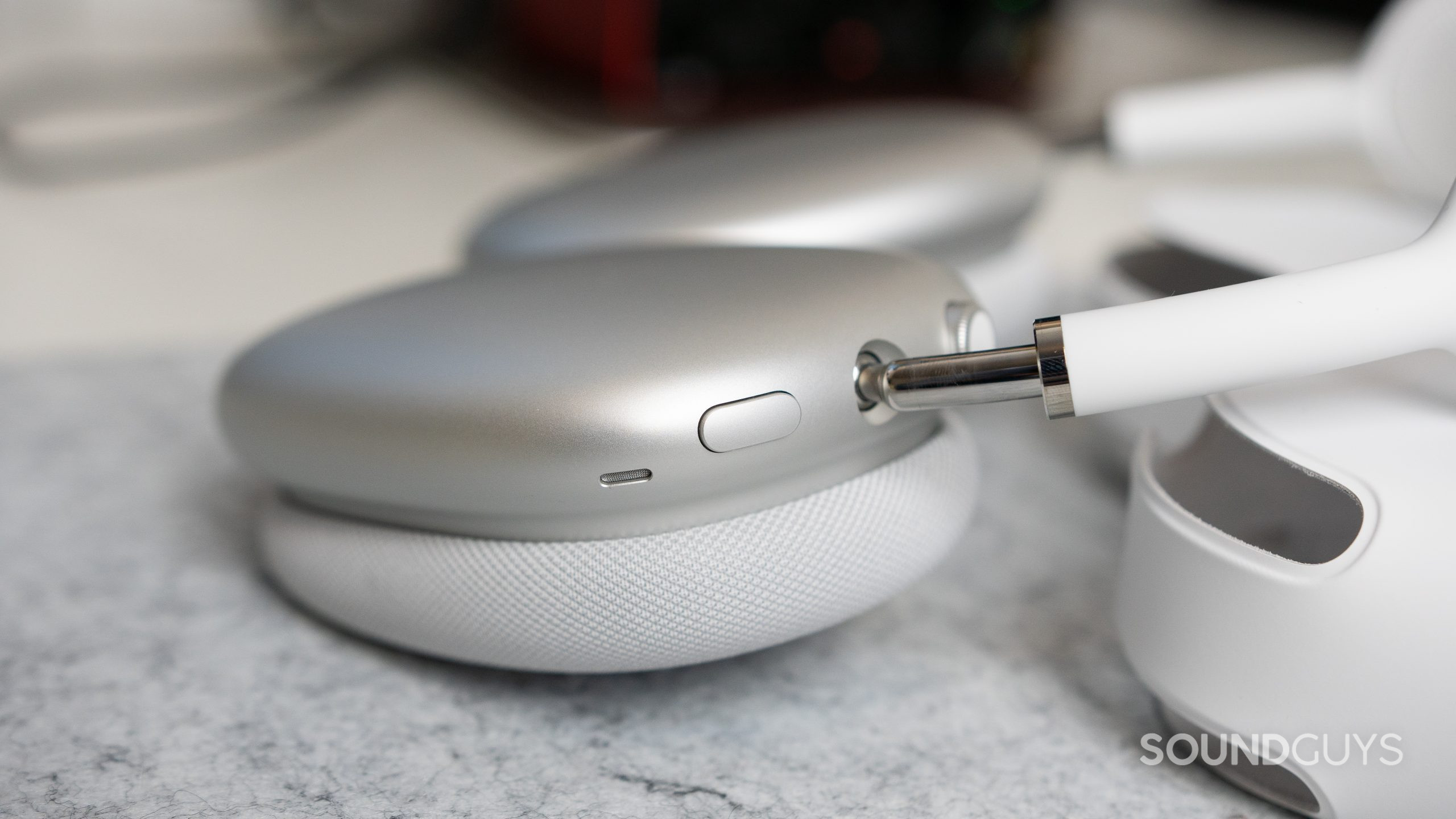 Apple AirPods Max noise canceling toggle. Close-up of the noise canceling toggle on the Apple AirPods Max as it is on a desk.