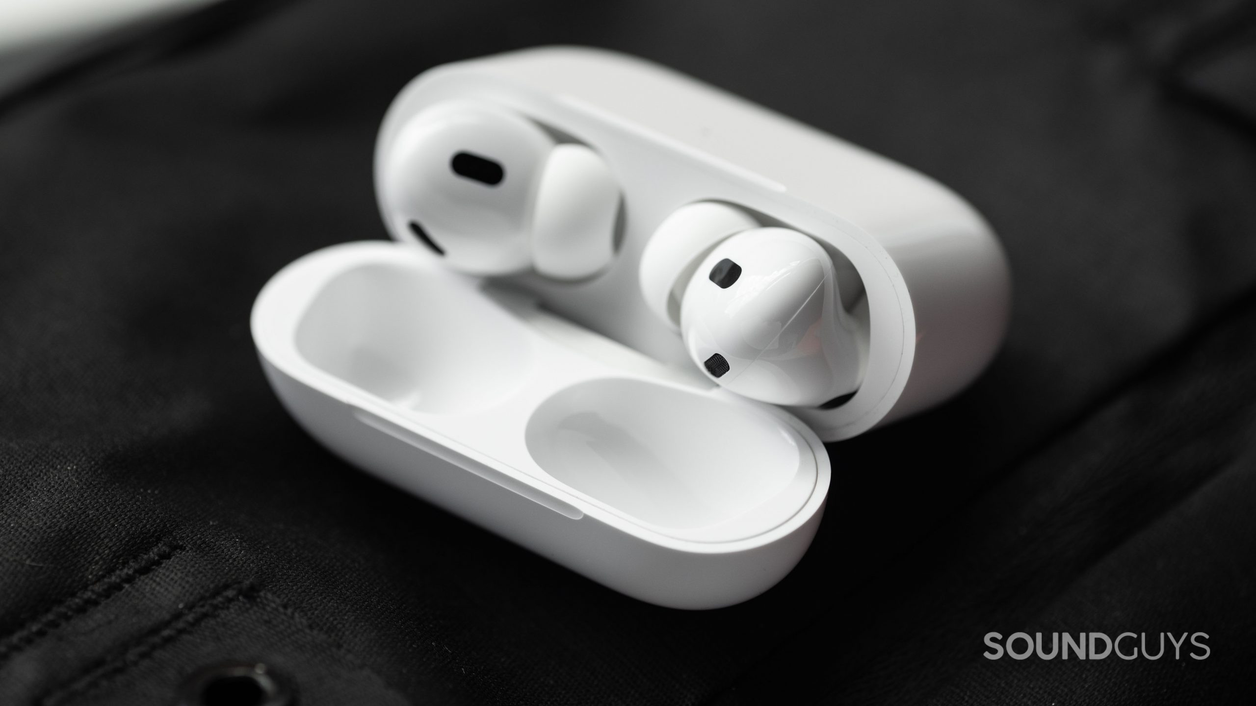 Apple AirPods Pro (2nd generation) true wireless earbuds case open angled The Apple AirPods Pro (2nd generation) case is open and laying at an angle to show the earbuds and their sensors.