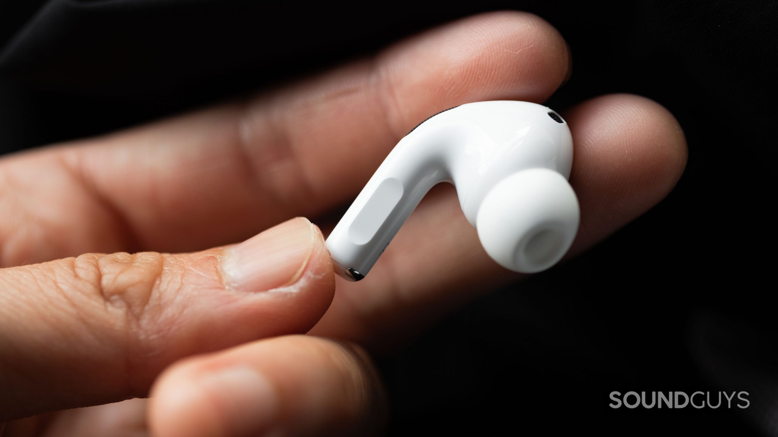 Apple AirPods Pro (2nd generation) true wireless earbuds stem control hand A hand holds the right earbud of the Apple AirPods Pro (2nd generation) to show off the stem.