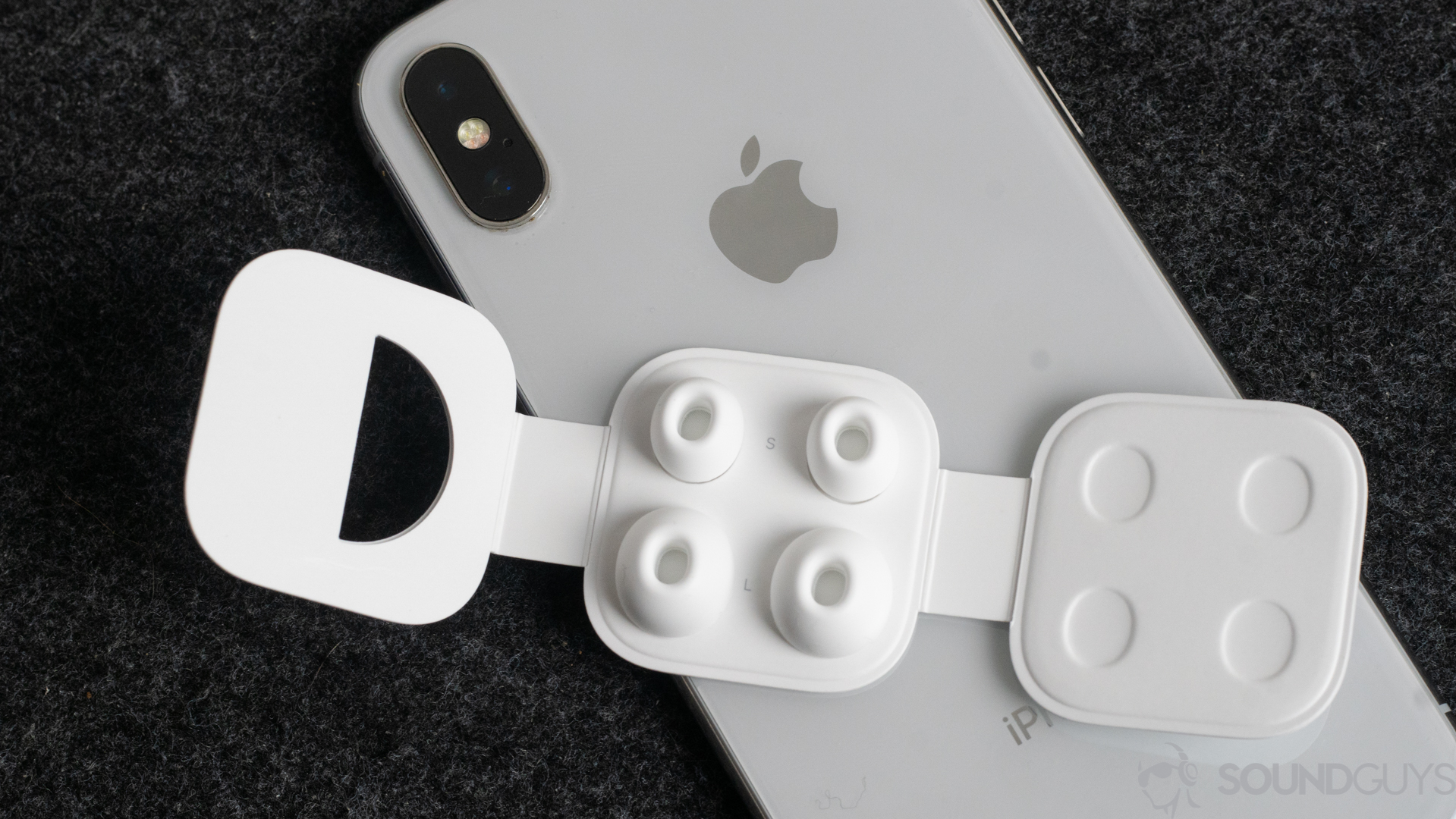 Apple AirPods Pro-3 Top-down shot of the eartips on a white iPhone X.