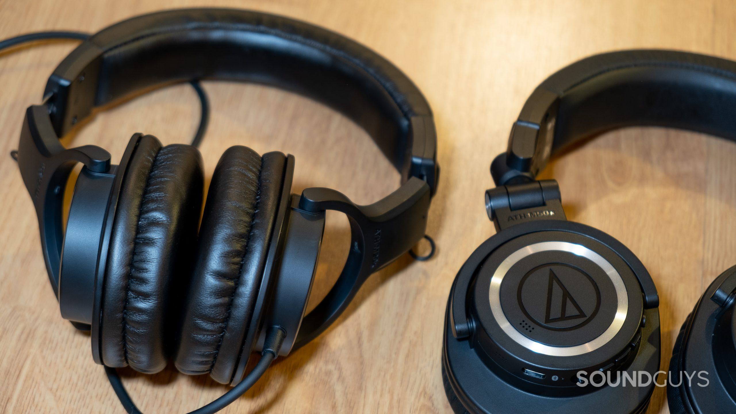 audio-technica-ath-m20x-and-ath-m50xbt2 The Audio-Technica ATH-M20x sitting next to the Audio-Technica ATH-M50xBT2 on a wood surface.
