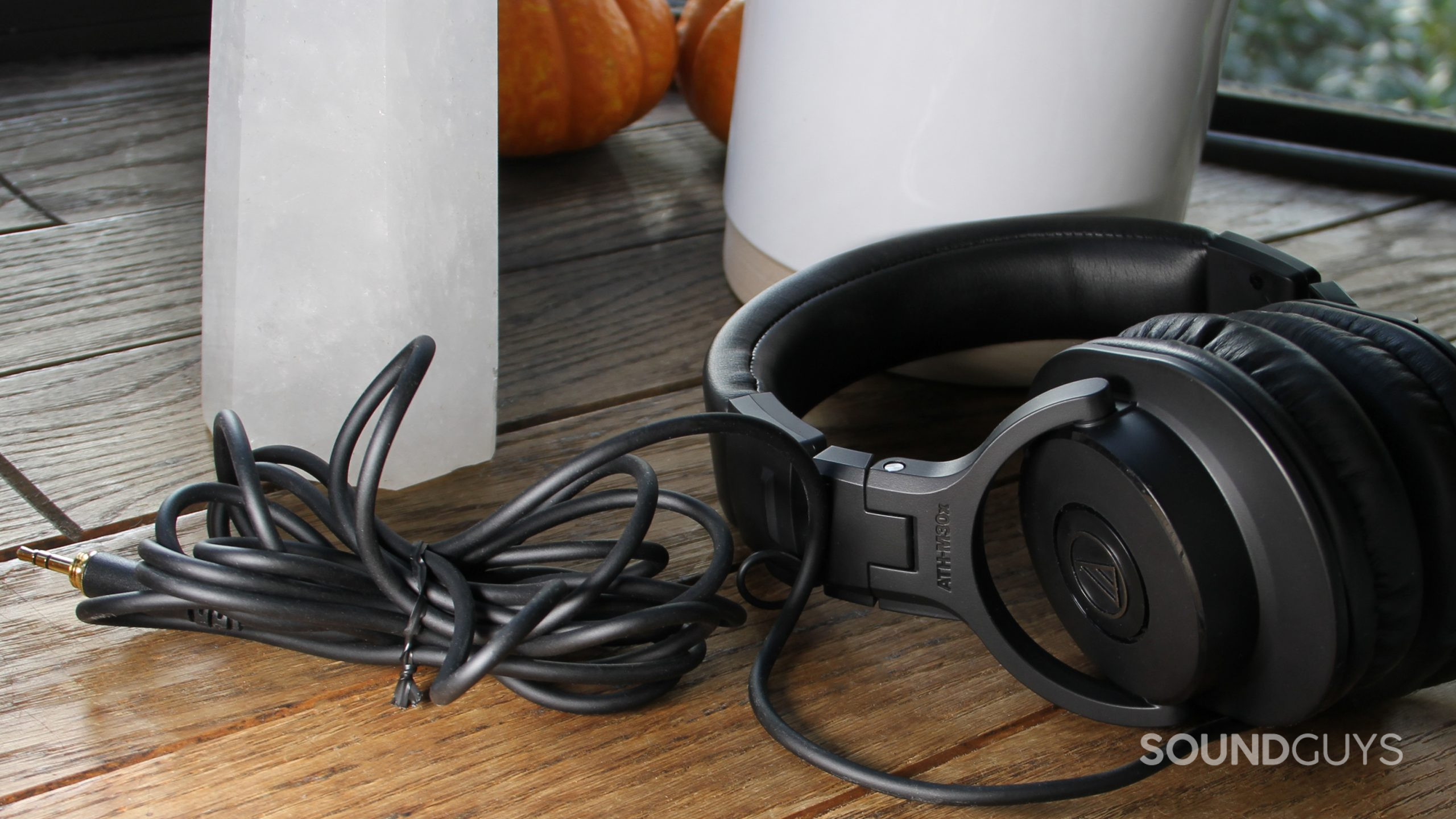 audio technica ath m30x cable The Audio-Technica ATH-M30x resting on a wood surface with the cable folded up.