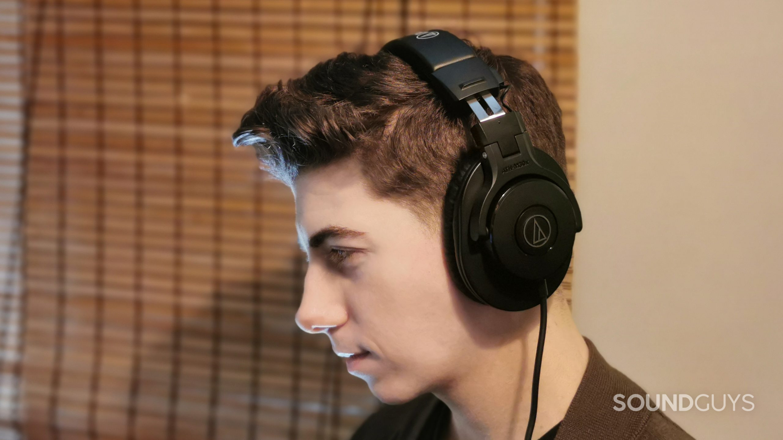audio-technica-ath-m30x-on-ears A man faces left wearing the Audio-Technica ATH-M30x.