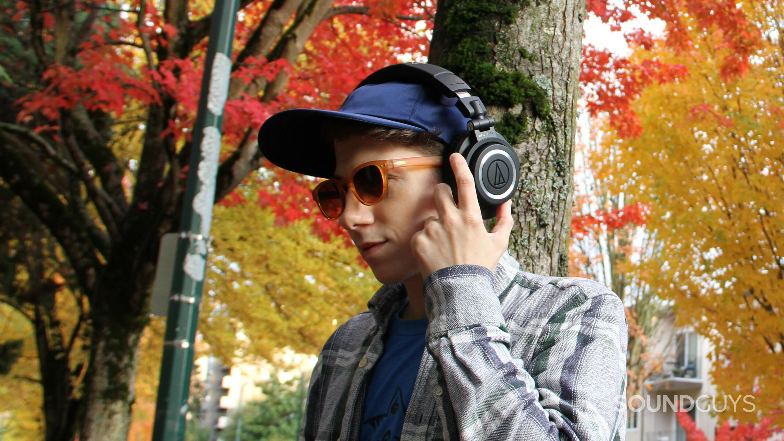 audio-technica-ath-m50xbt2-on-head-buttons1 A man wears the Audio-Technica ATH-M50xBT2 pressing the buttons on the left ear cup.