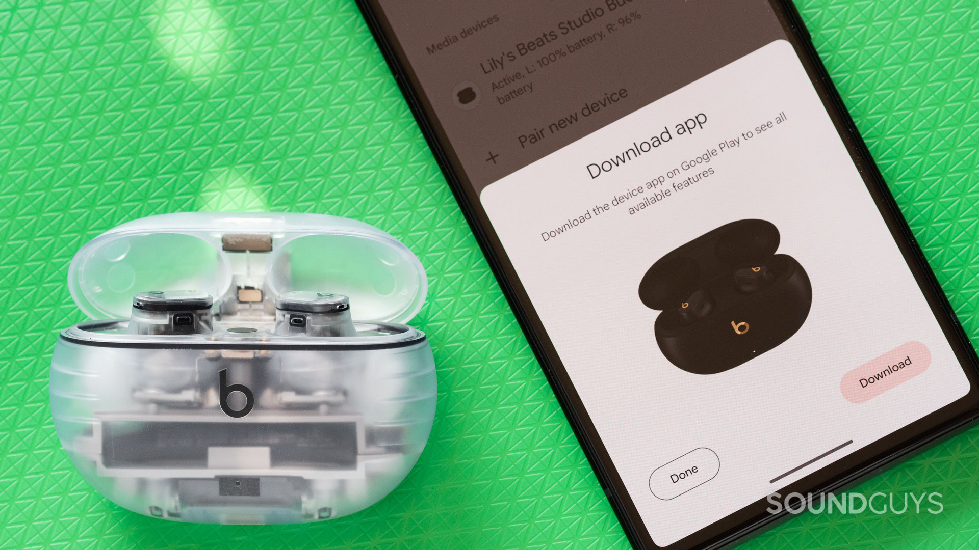 The Beats Studio Buds Plus next to a phone, while connecting.