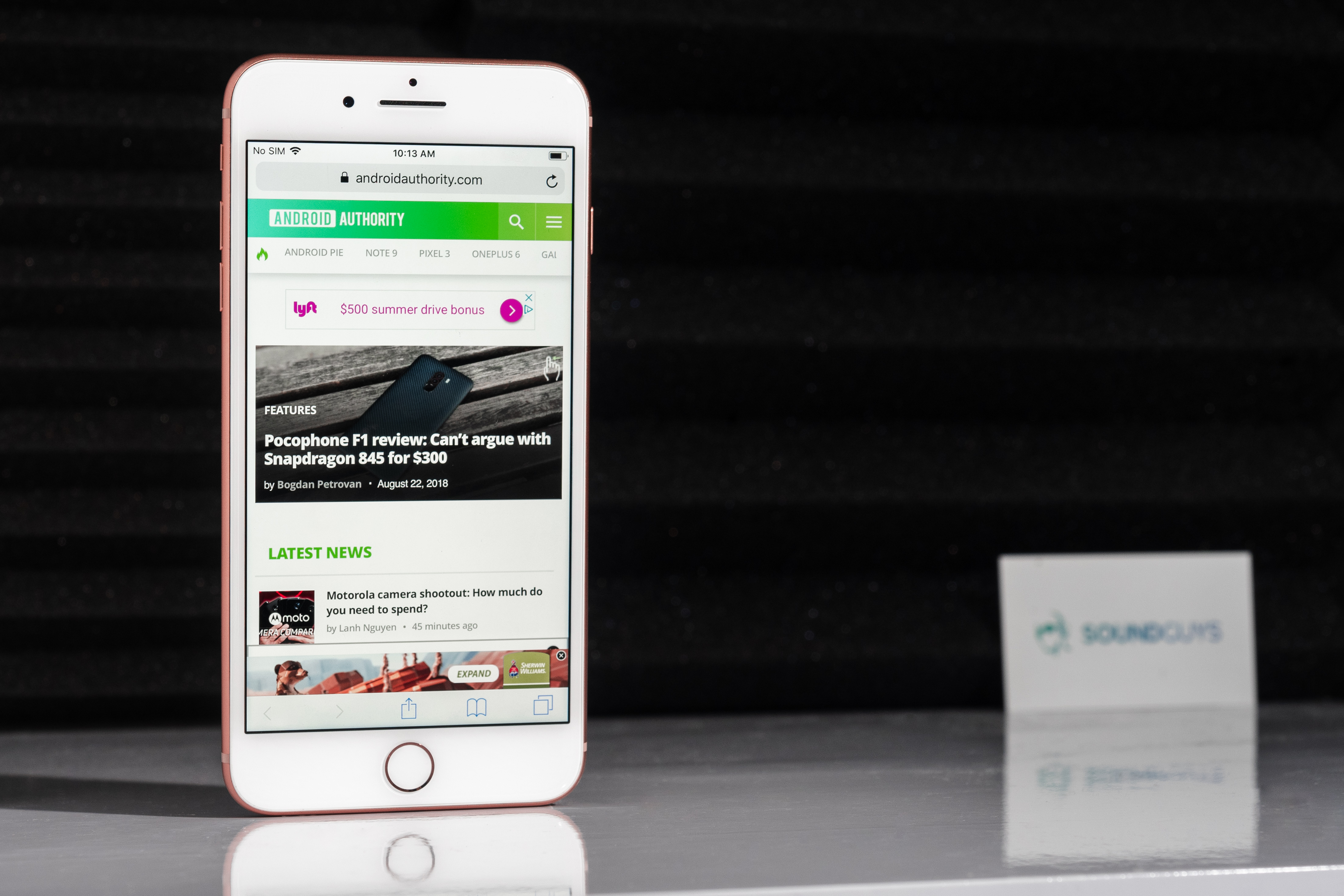 Best iPhone earbuds hero LK Best iPhone earbuds: Image of an iPhone 8 Plus with Android Authority pulled up. The background consists of soundproofing and a SoundGuys business card.