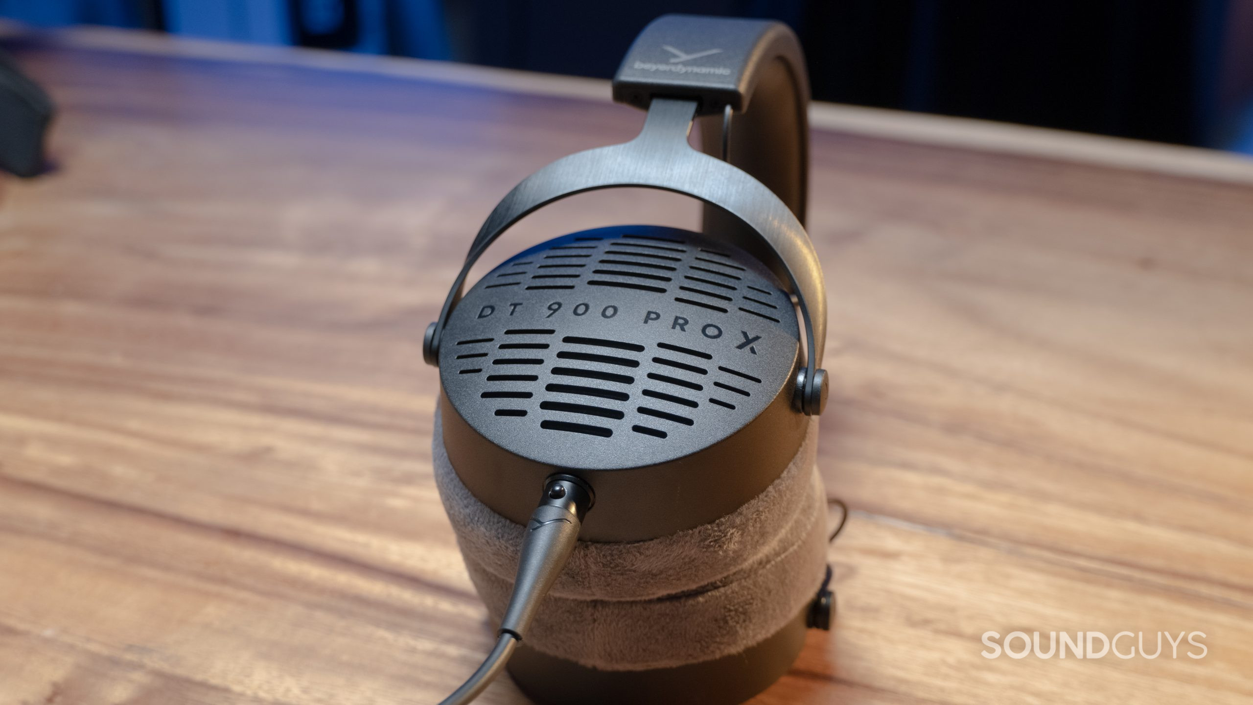 Beyerdynamic-DT-900-Pro-X-plugged-in The Beyerdynamic DT 900 Pro X sits on a wood grain table.