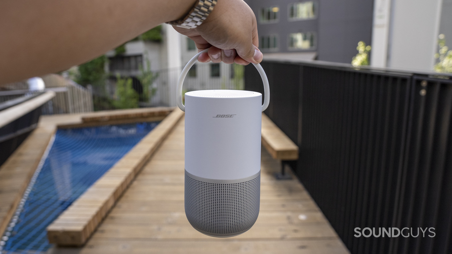 bose-portable-smart-speaker-7 A hand holding a Bose Portable Smart Speaker by its built-in carrying handle.