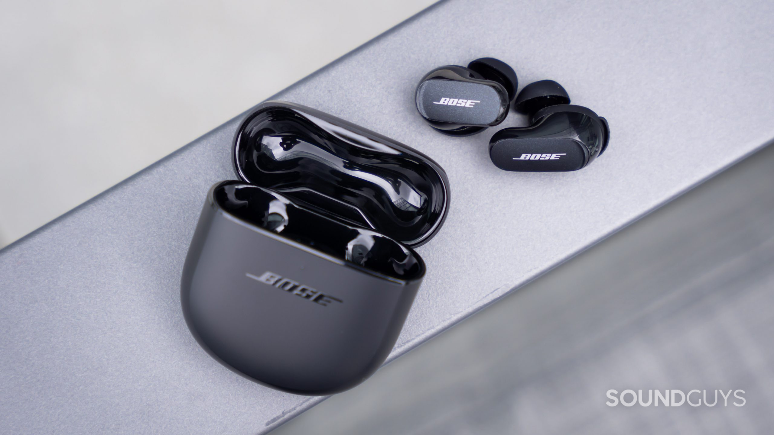 Bose QuietComfort Earbuds II true wireless noise canceling case earbuds bright light An aerial view of the Bose QuietComfort Earbuds II with the open case and earbuds, as if the buds are spilling out.