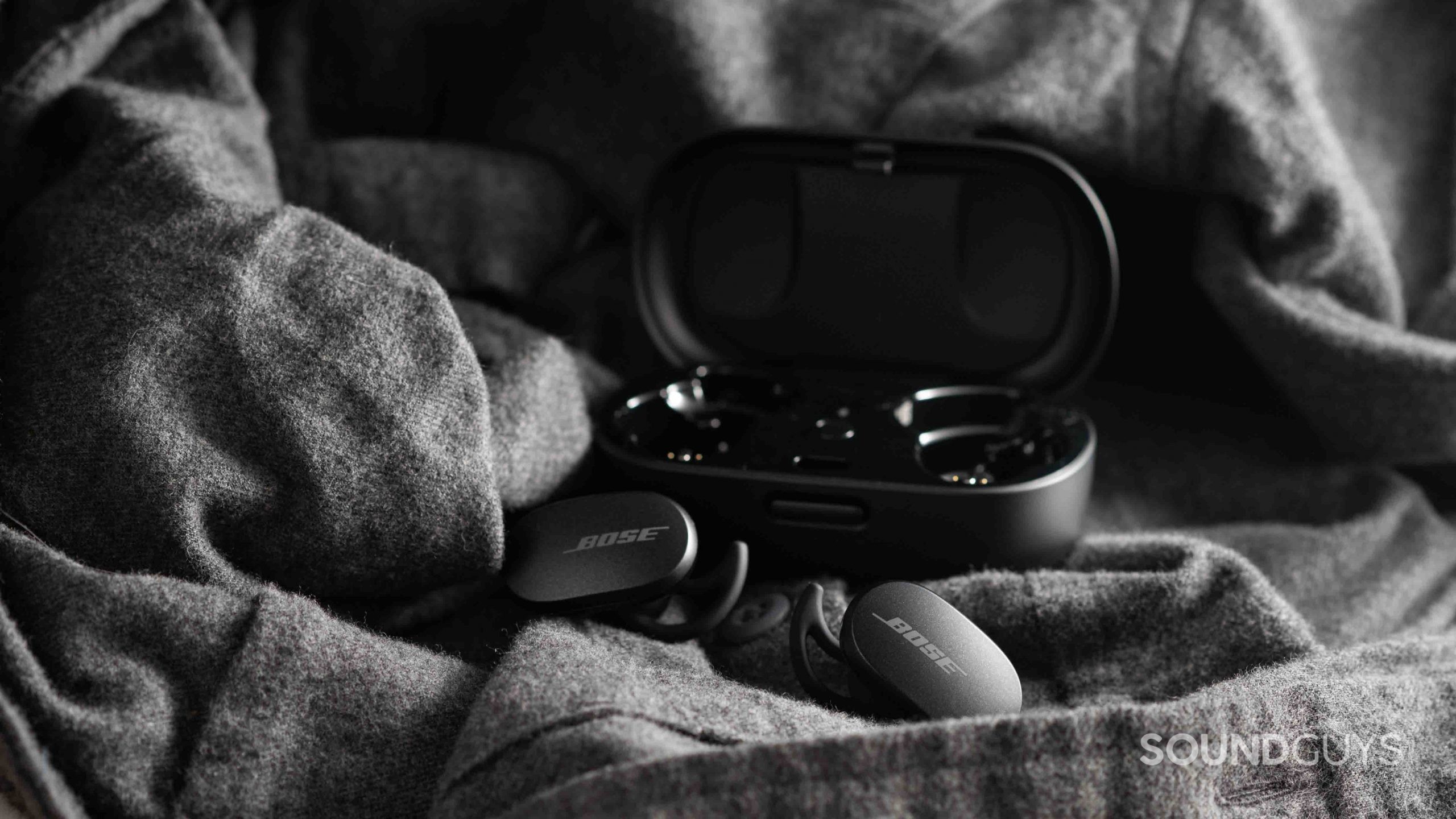 Bose QuietComfort Earbuds noise canceling true wireless-2 The Bose QuietComfort Earbuds noise canceling true wireless earbuds rest outside of the open charging case.