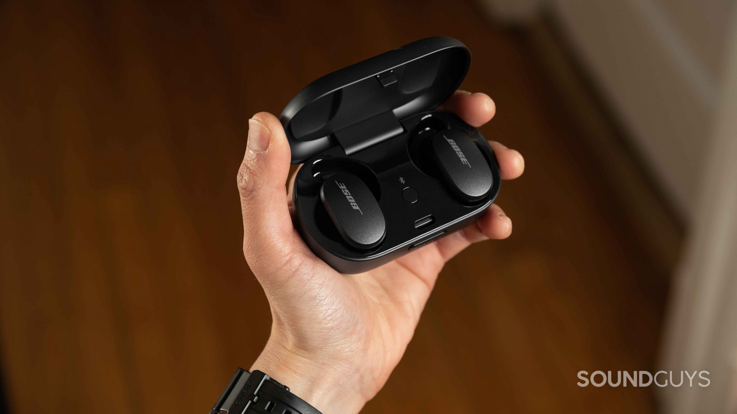 Bose QuietComfort Earbuds noise canceling true wireless-4 A hand holds the Bose QuietComfort Earbuds noise canceling true wireless earbuds open charging case.