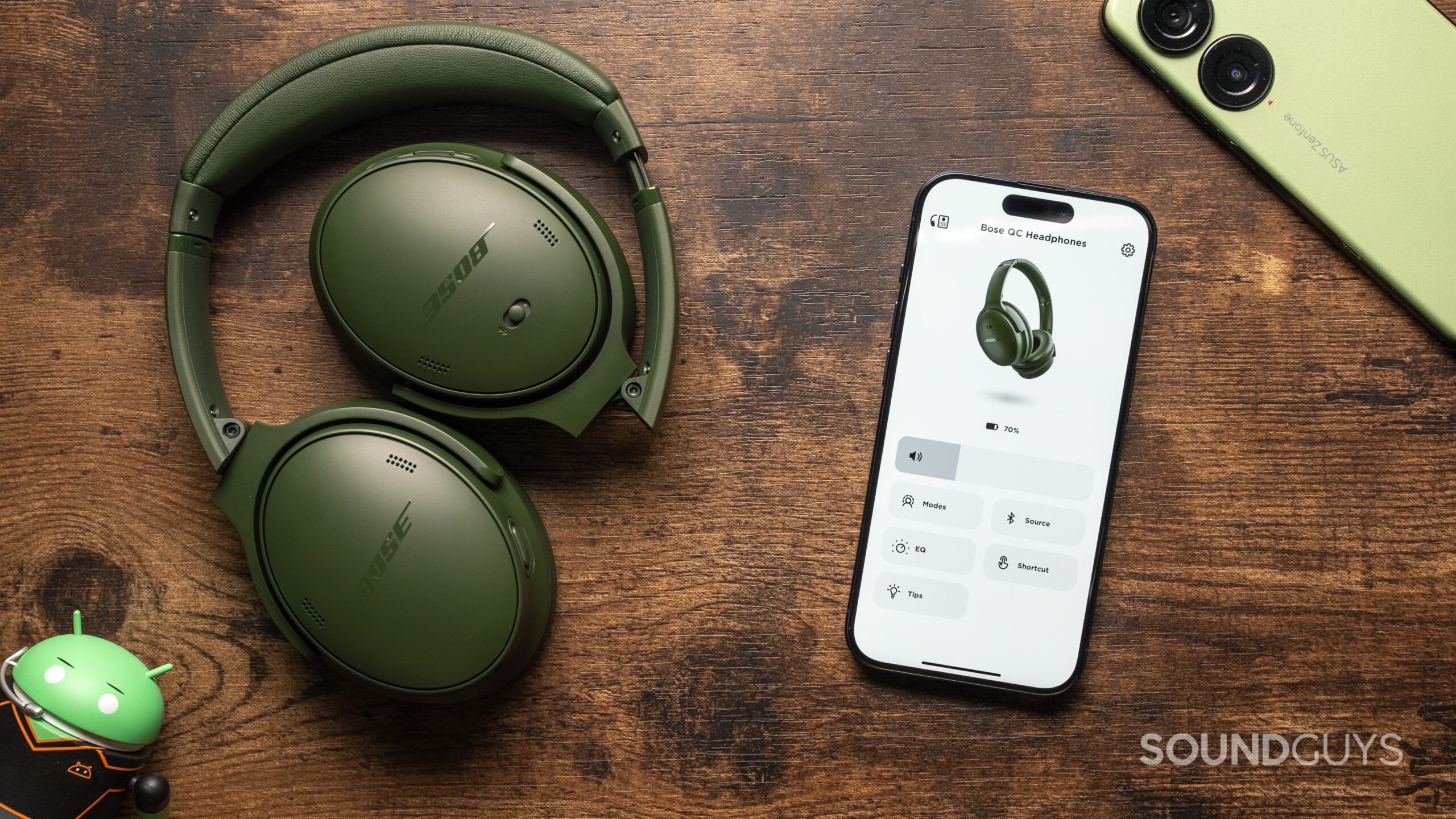 bose-quietcomfort-headphones-on-table-beside-phone-music-app The Bose QuietComfort Headphones sitting atop a table, with the Bose Music App open on a phone.
