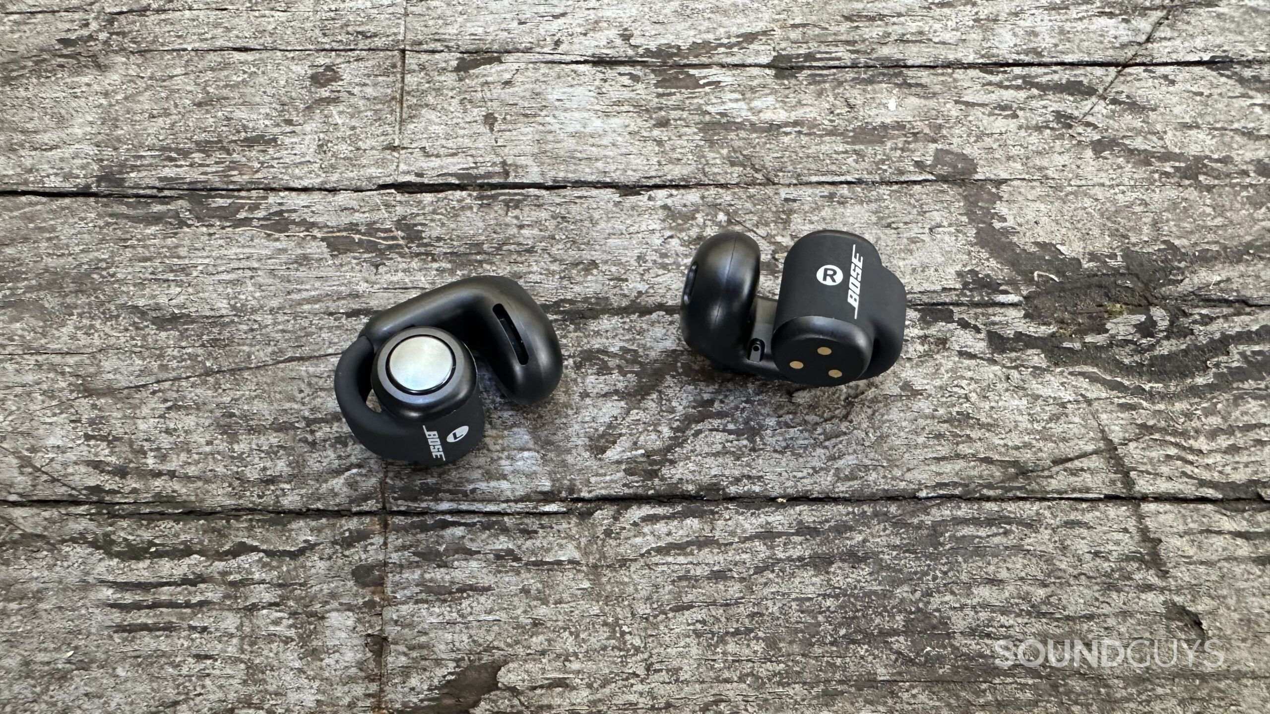 Bose UOE close up Bose Ultra Open Earbuds on a grey bench