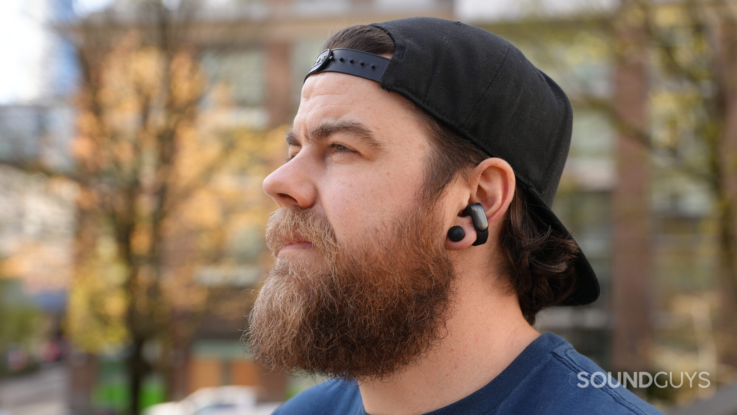 Dave Bose UOE Outside 2 A man wearing the Bose Ultimate Open Earbuds looking off into the distance.