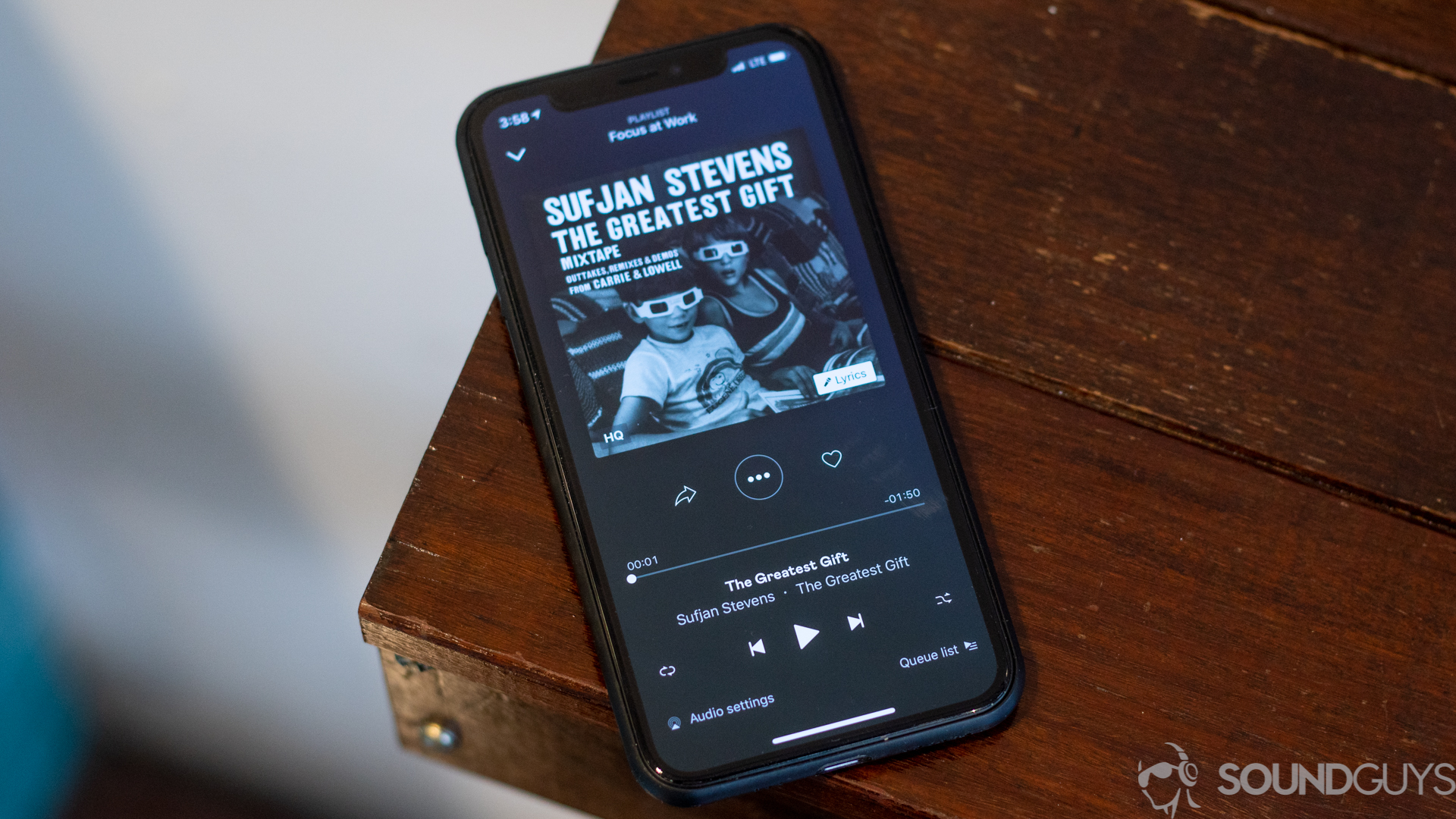 Deezer app now playing screen Pictured is the main playing now section of the Deezer app on an iPhone 11 Pro on wood table.