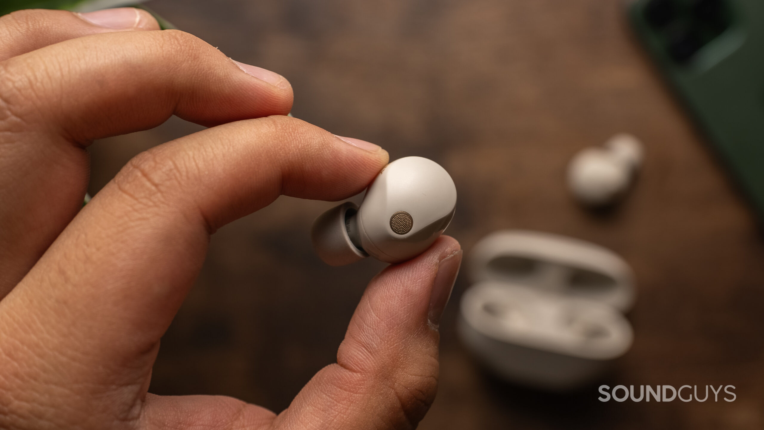 Sony WF-1000XM5 left earbud Holding the left earbud of the Sony WF-1000XM5 in hand