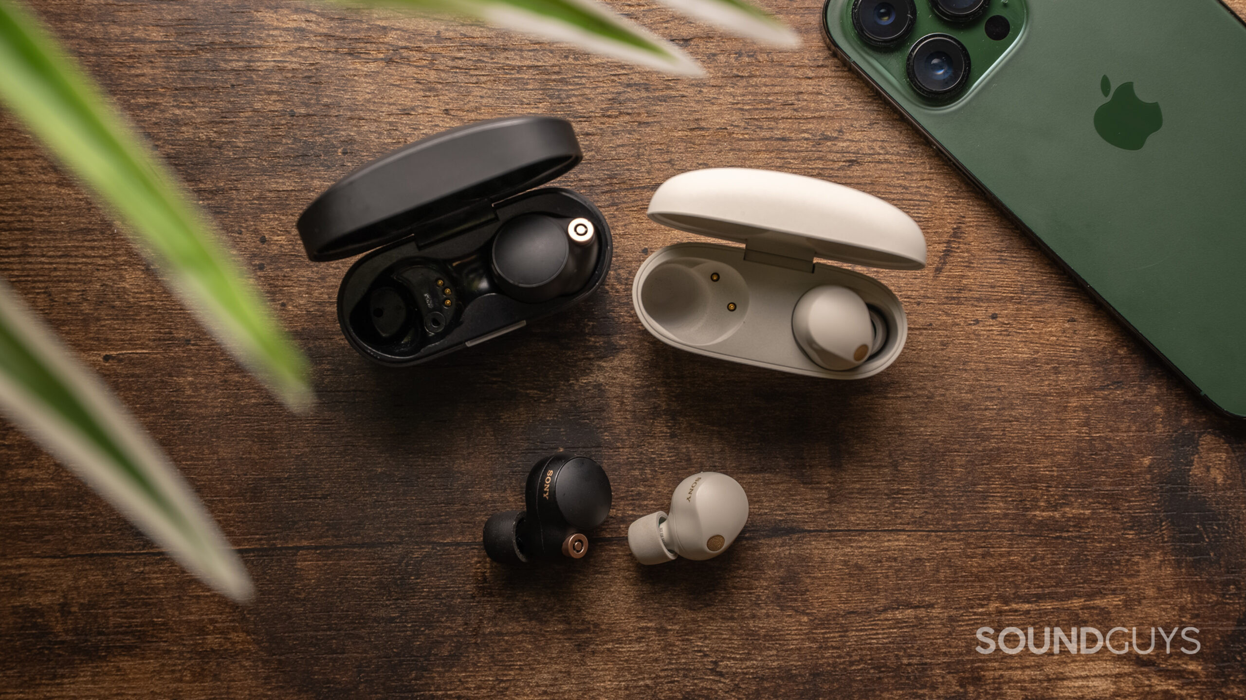 Sony WF-1000XM4 earbud outside of case vs. Sony WF-1000XM5 earbud outside of case The Sony WF-1000XM4 charging case open next to the Sony WF-1000XM5 charging case with one ear bud in front of the case from each product