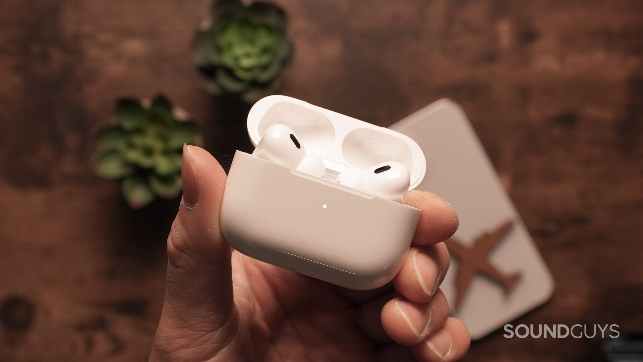 AirpodsPro-Closeup1 A hand holds the AirPods Pro in their case, open.