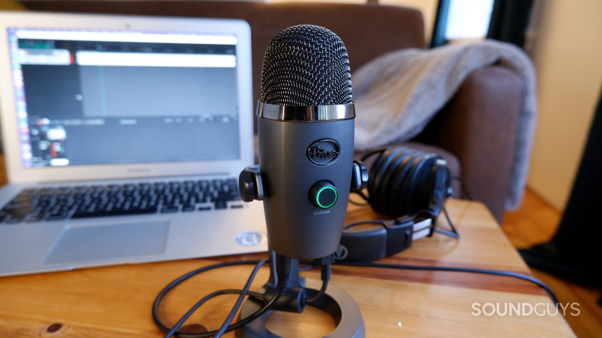 Blue Yeti Nano desktop recording Blue Yeti Nano microphone sitting on a wooden table in front of a laptop and a pair of headphones.