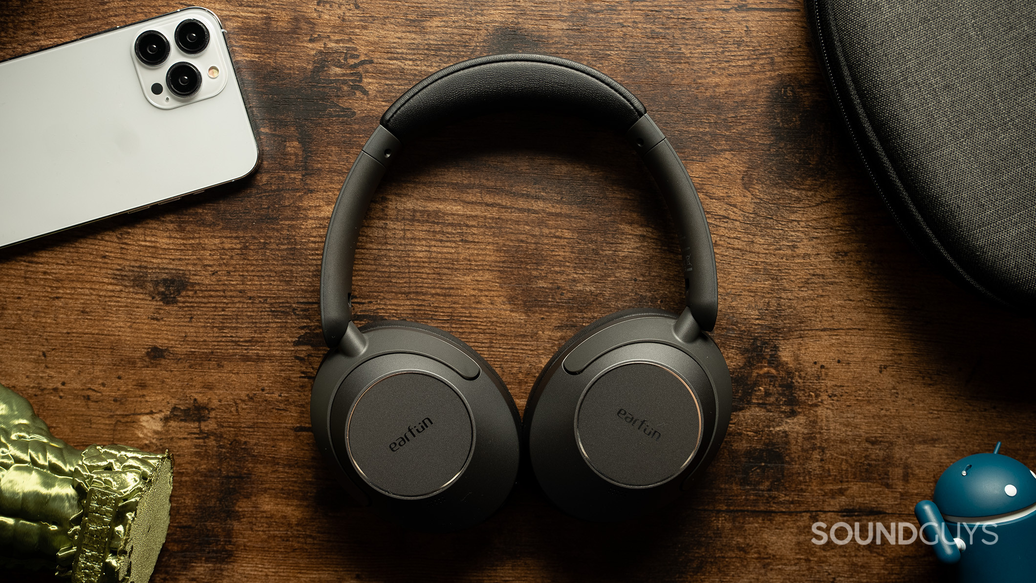 EarFun Wave Pro headphones on desk EarFun Wave Pro headphones next to an iPhone and some accessories.