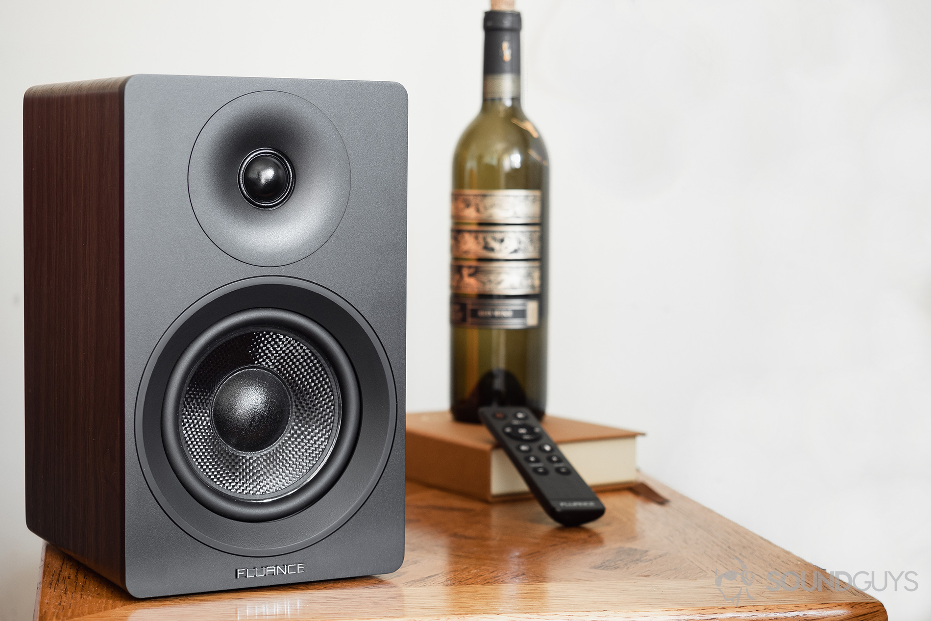 Fluance_Ai40_LK_10 Fluance Ai40 review: The passive speaker on a table with a wine bottle in the background and the remote.