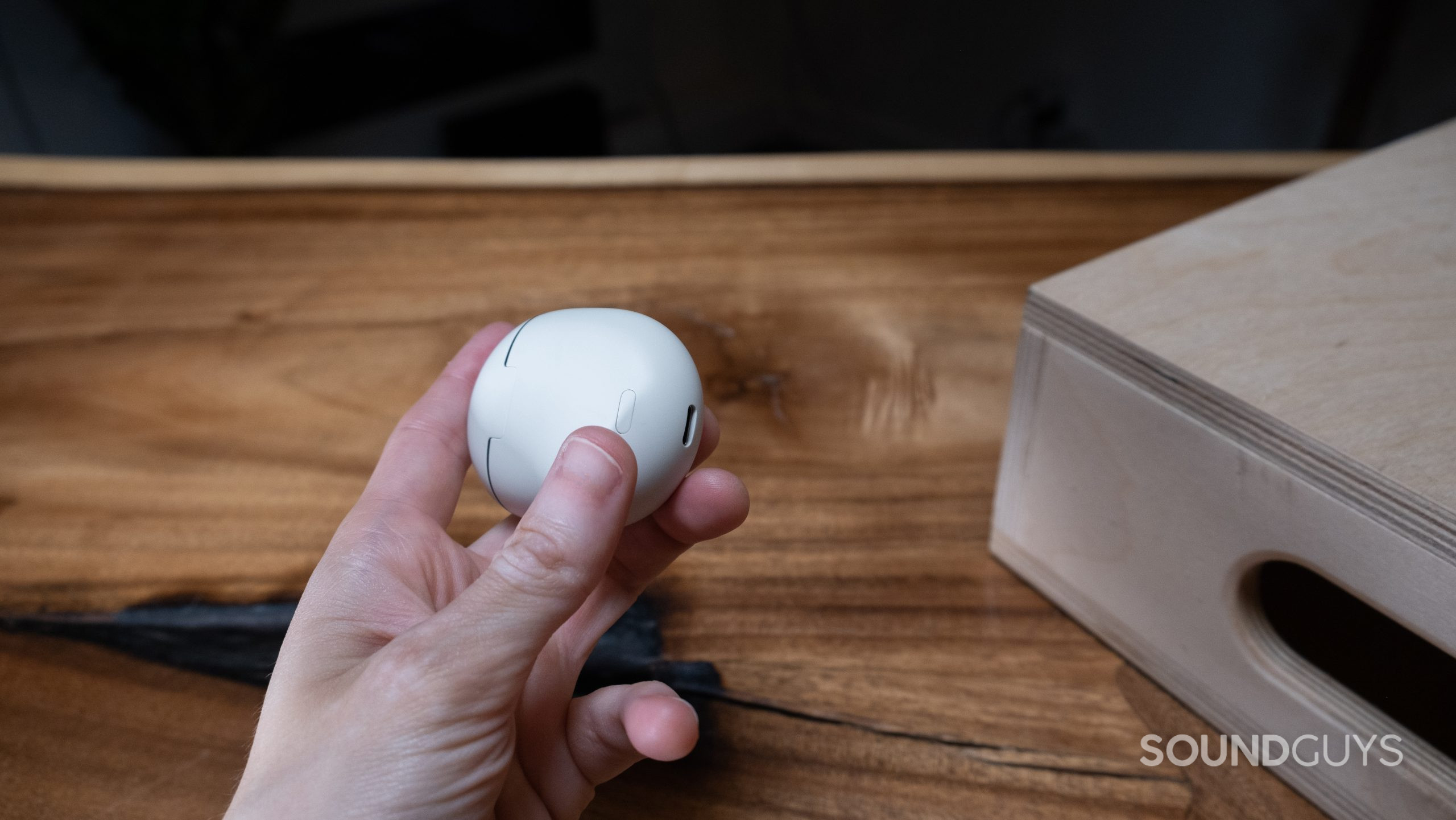 google-pixel-buds-back-button A hand holds the closed Google Pixel Buds Pro case showing the USB-C connection and the pairing button.