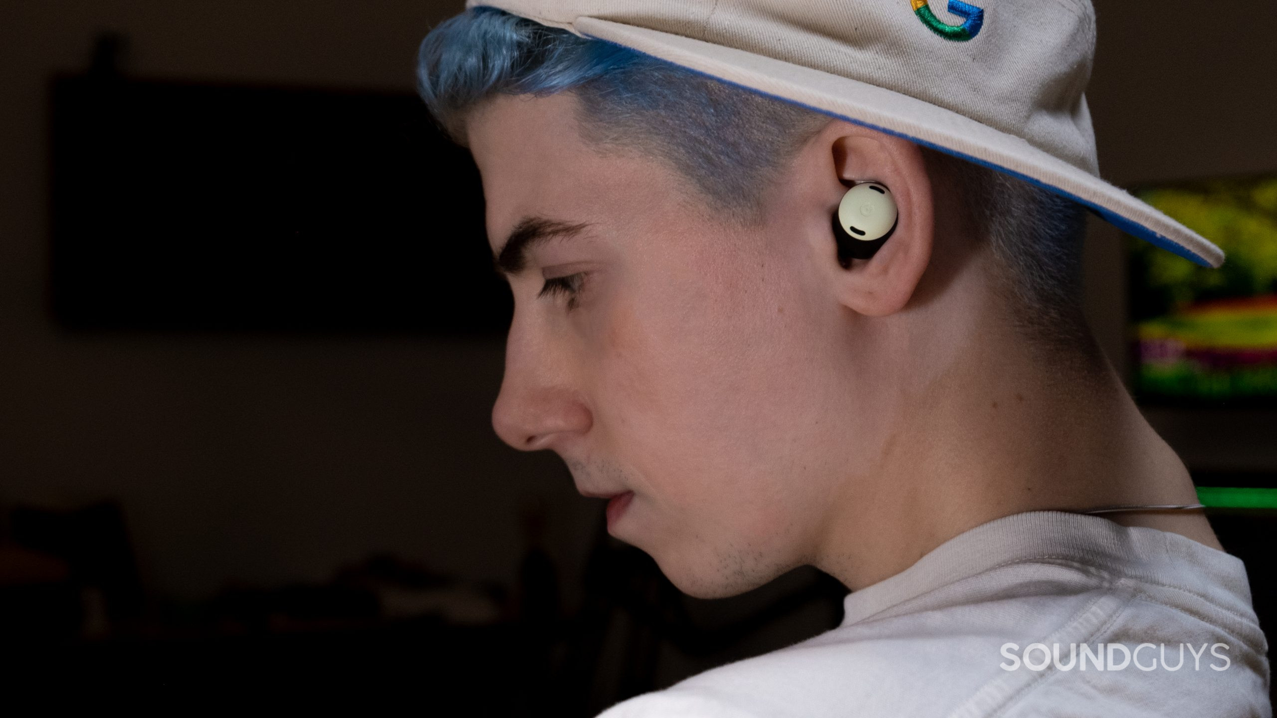 google-pixel-buds-pro-in-ears A man faces right with a dark background and a bright monitor. He's wearing the Google Pixel Buds Pro.