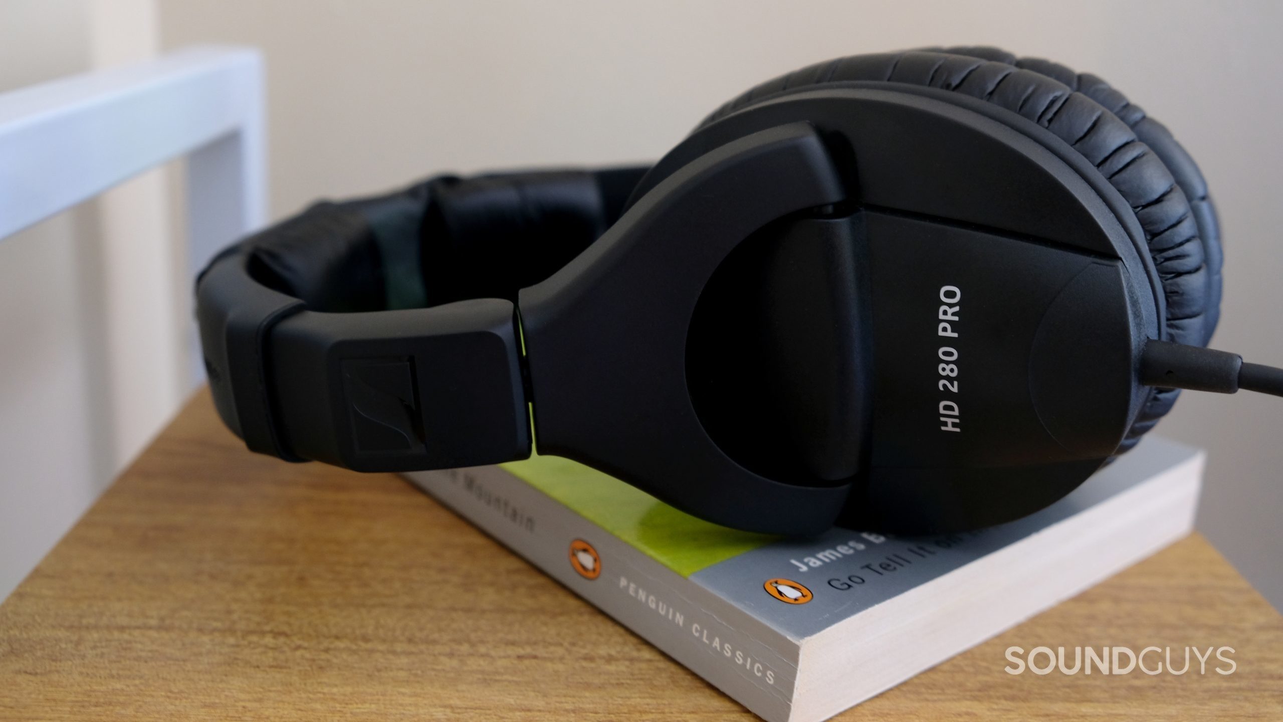 Sennheiser hd 280 pro close up 01 A set of Sennheiser HD 280 Pro sits atop a James Baldwin book on a wood shelf.