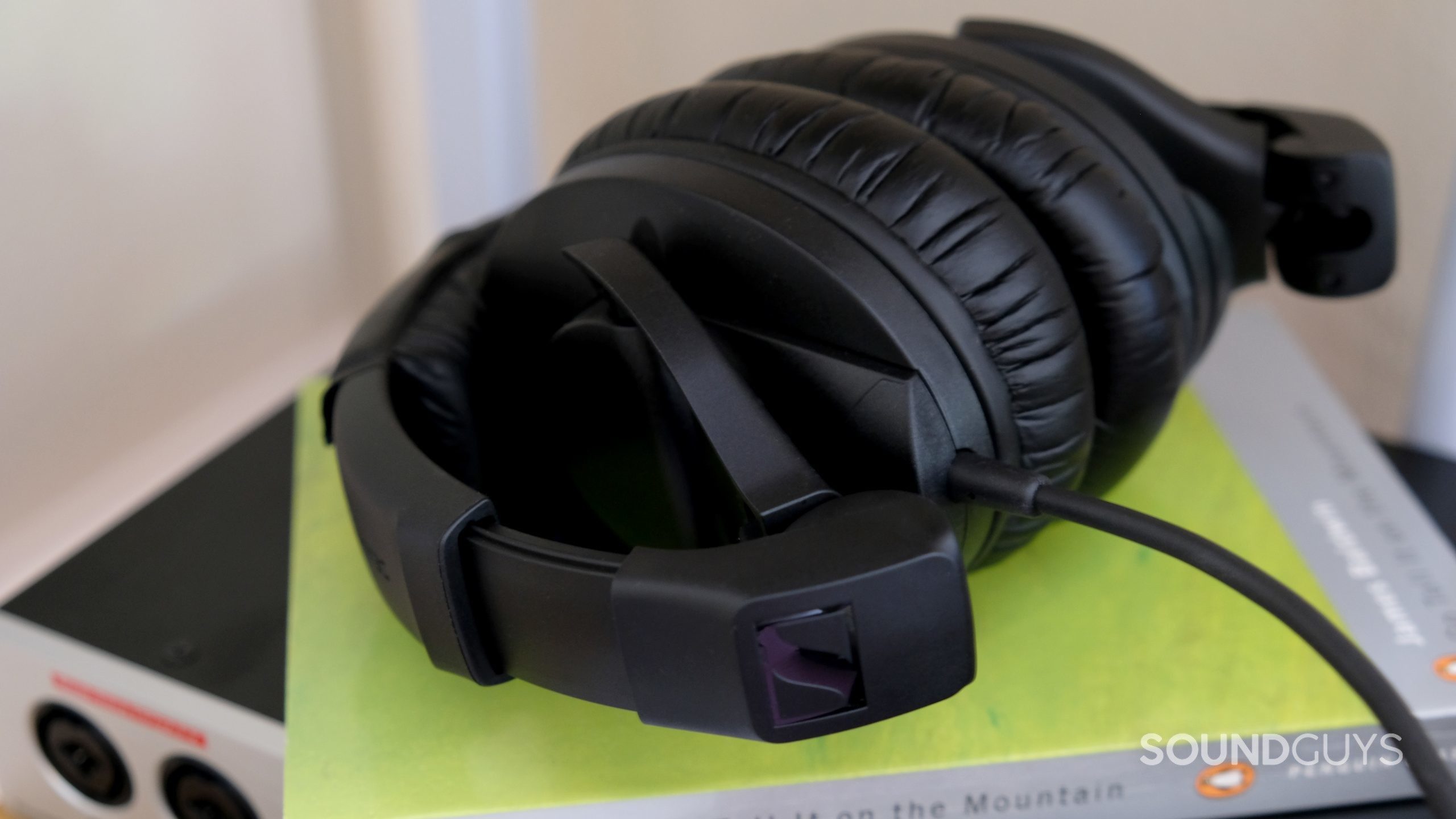 Sennheiser hd 280 pro close up 03 The Sennheiser HD 280 Pro studio headphones folded on a green book with the cable in full view.