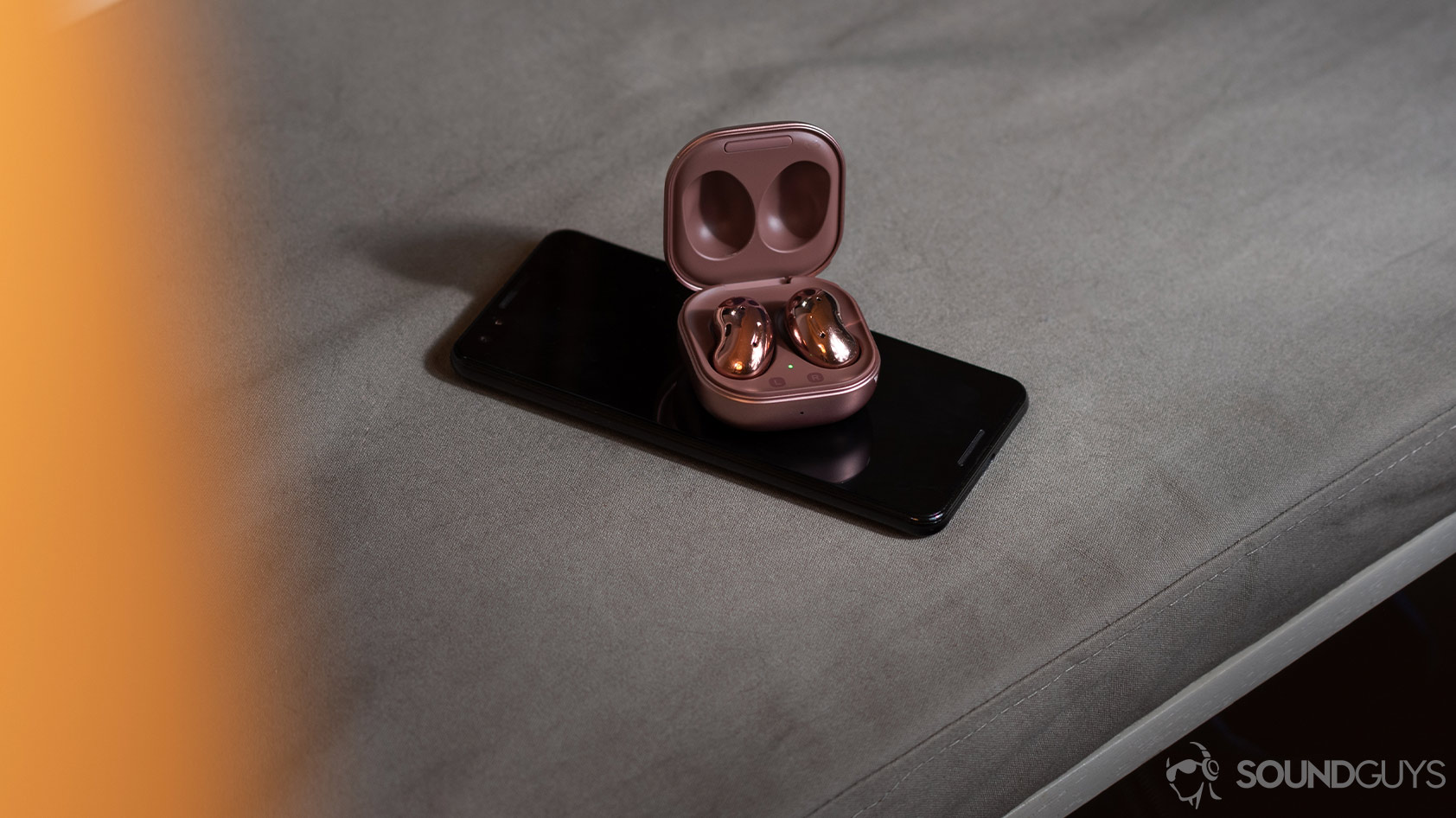 headphone data collection-Samsung Galaxy Buds Live The Samsung Galaxy Buds Live on a Google Pixel 3 smartphone, both of which are on a gray surface.