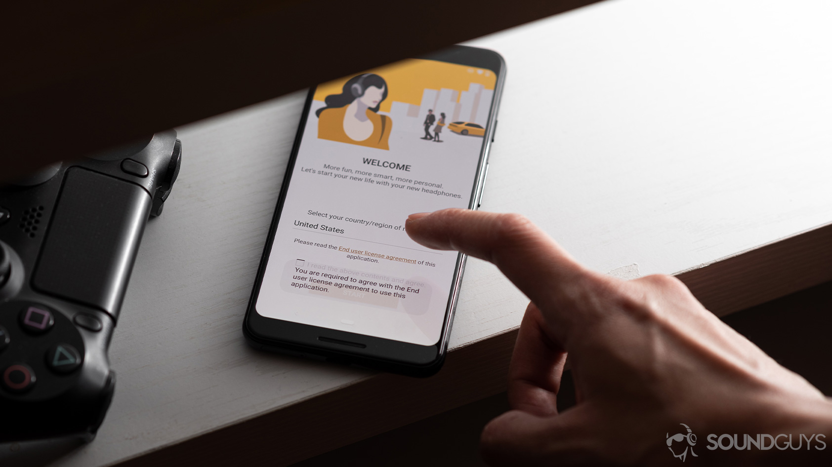 headphone data collection-Sony Headphones Connect app hand The Sony Headphones Connect headphone app on a smartphone with a hand reaching out to the terms of use warning.