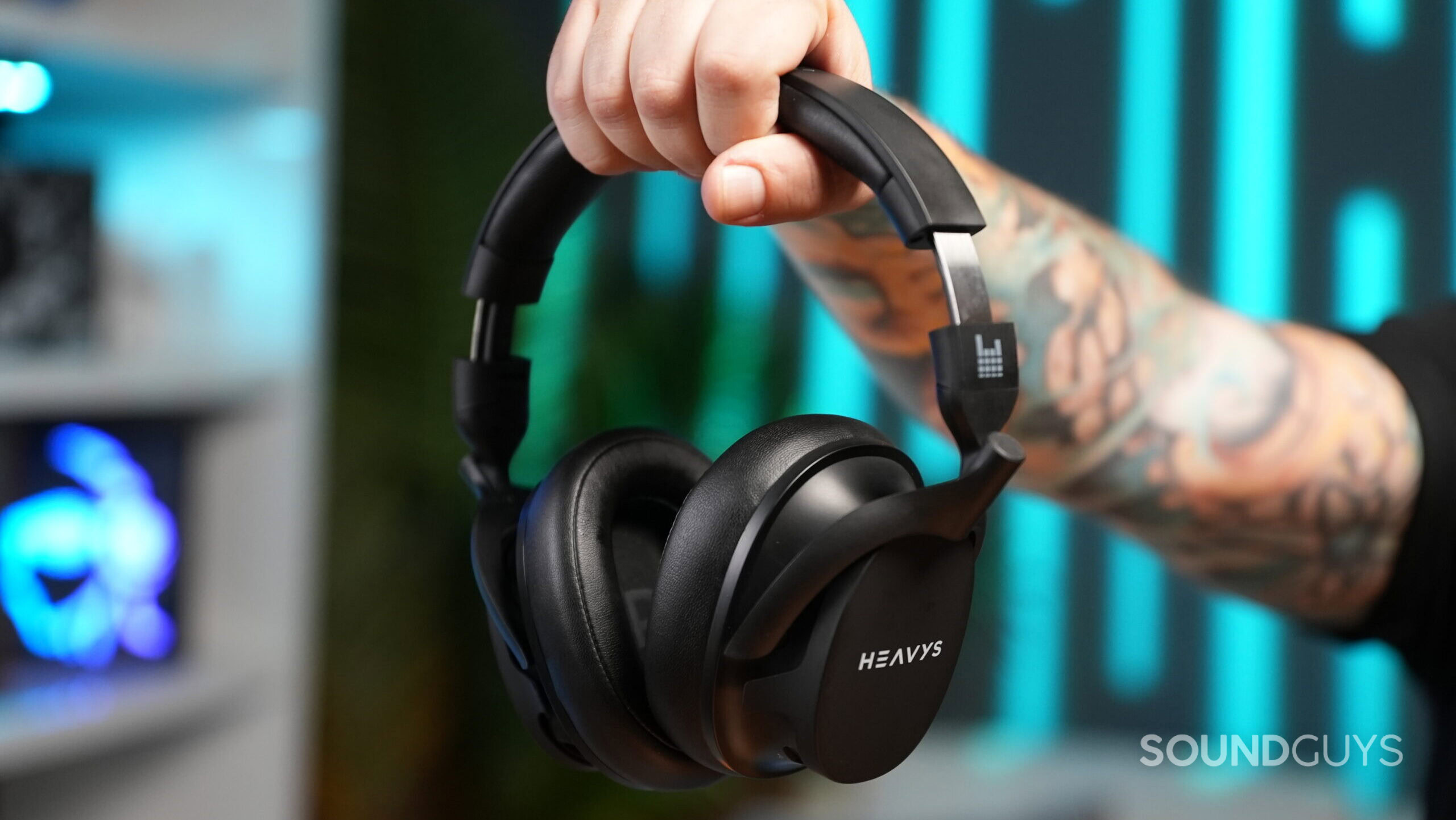 Heavys H1H in hand A hand holding the Heavy H1H headphones by the headband.