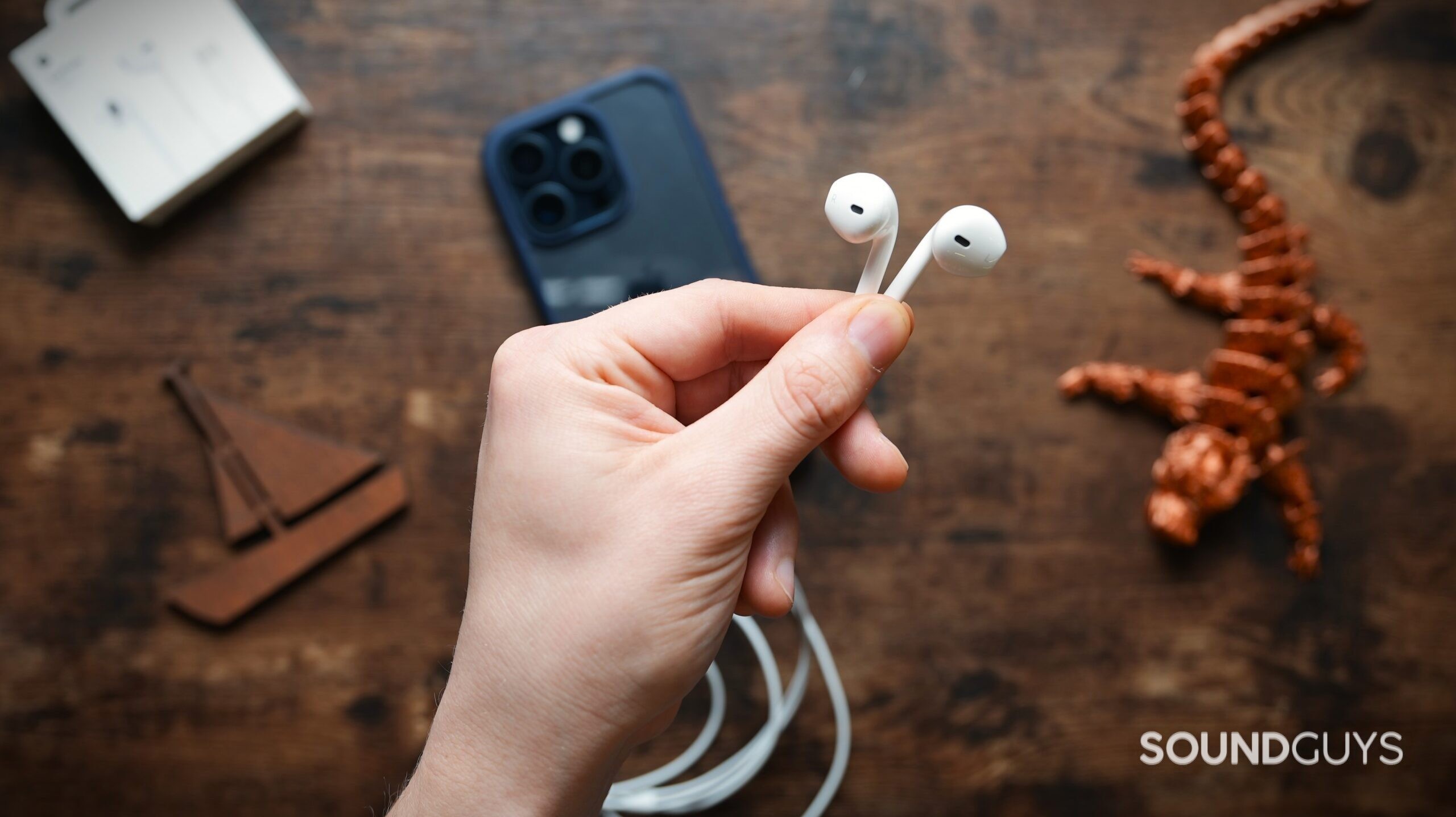 holdingAppleEarPods A hand holding the Apple EarPods in their fingertips.