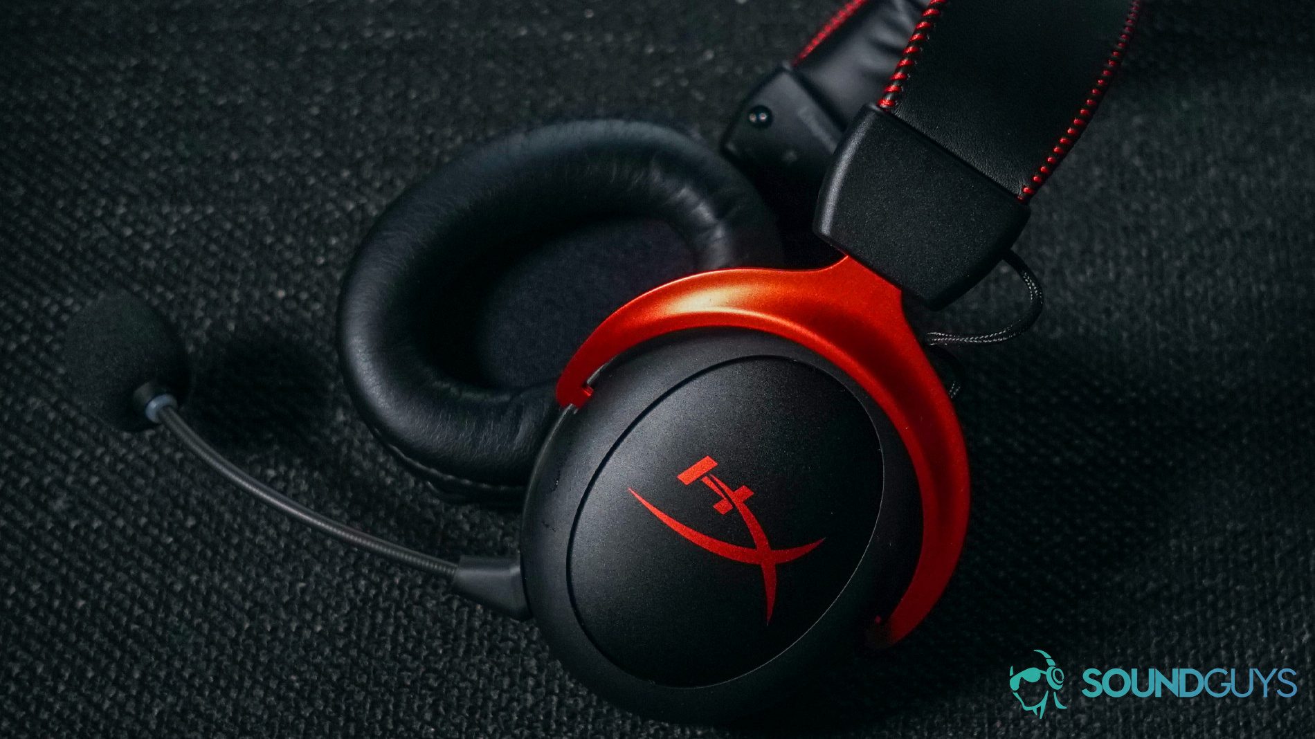 HyperX CLoud II Wireless Chair shot The HyperX Cloud II Wireless gaming headset lays on a fabric surface.