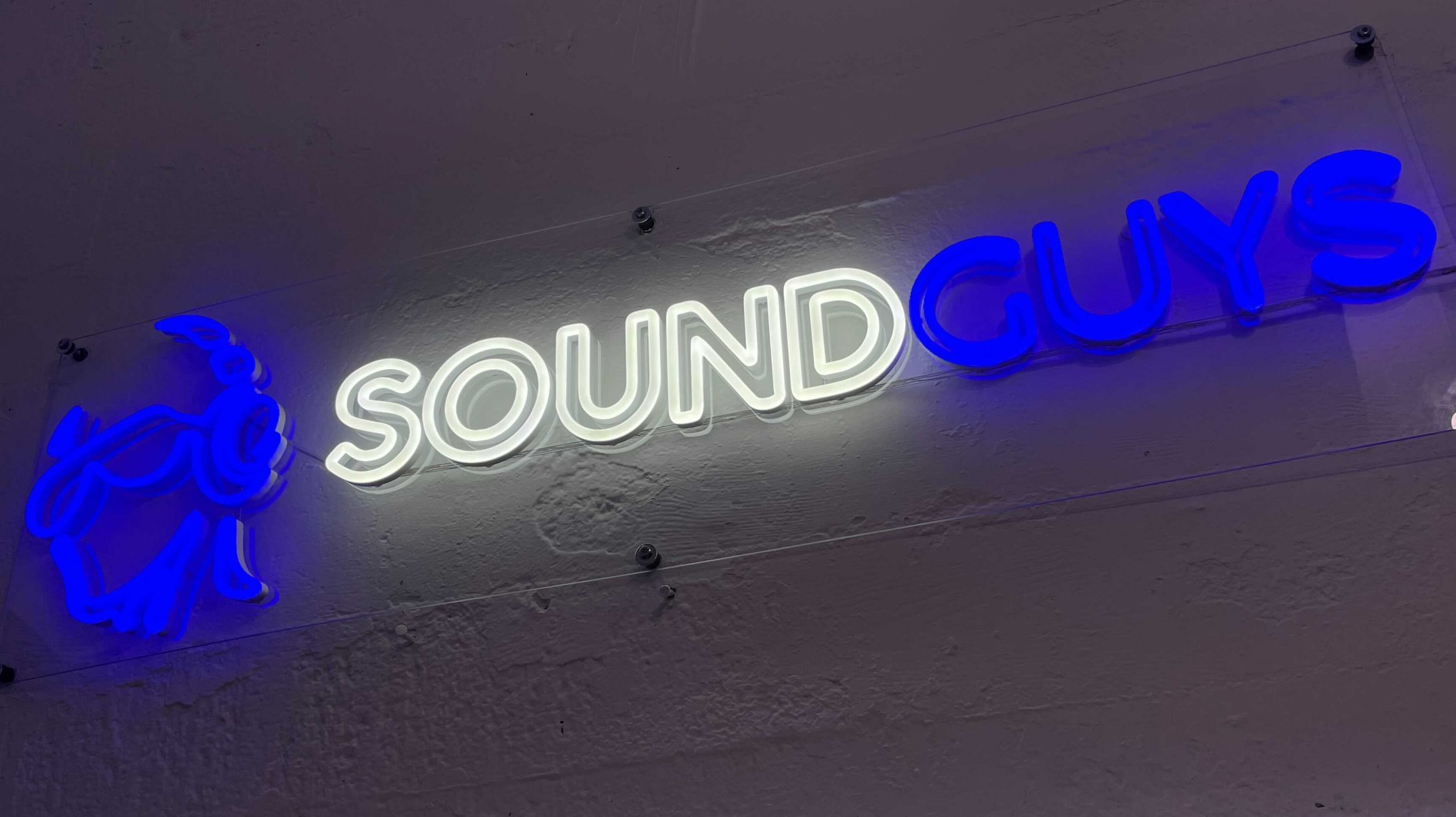Image from iOS SoundGuys neon sign glows on the wall.